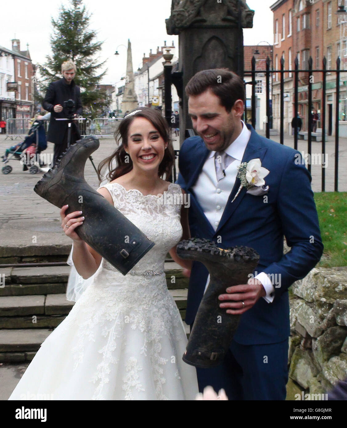 Lucy and Peter Nickson holding wellington boots outside Selby Abbey  following their wedding Stock Photo - Alamy