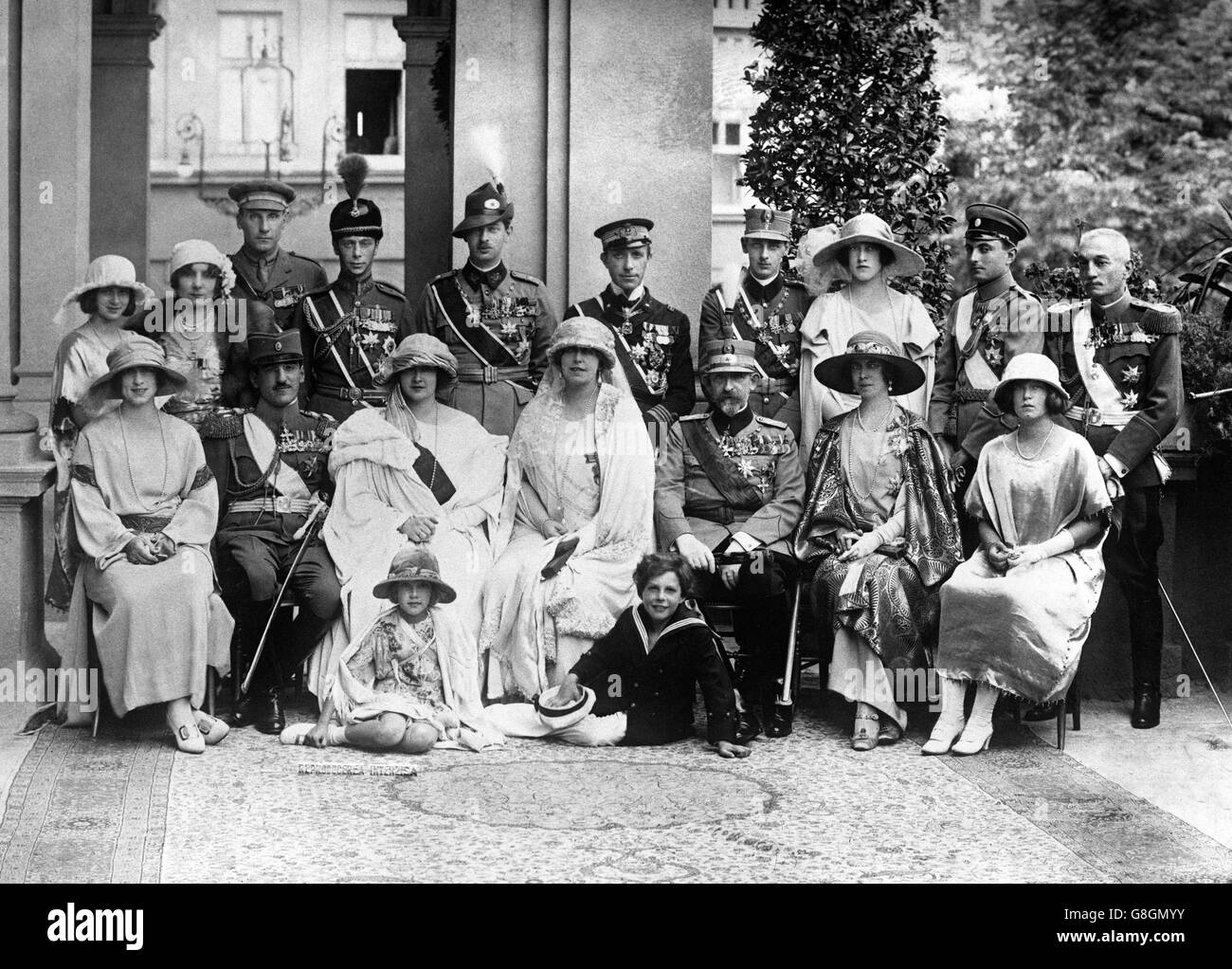 Family photograph from the marriage of Alexander, King of the Serbs, Croats and Slovenes, to Princess Marie of Roumania. The Duke of York (top row 4th from left) was representing King George V throughout the ceremony. In the foreground (l-r) Princess Helena of Rumania, King Alexander of Serbia, Queen Maria of Yugoslavia, Queen Maria of Rumania, King Ferdinand of Rumania, Princess Kira, Princess Beatrice. Stock Photo