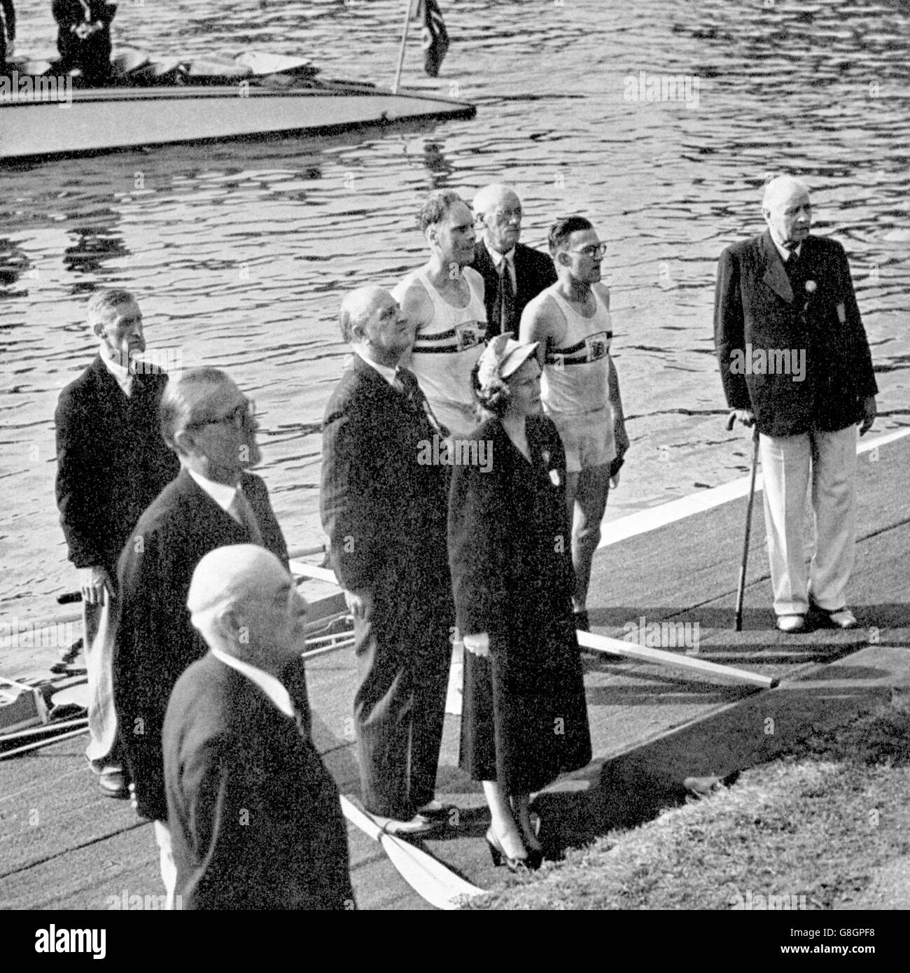 The gold medallists, Great Britain's Bertie Bushnell (l) and Richard Burnell (r), stand to attention as the national anthem is played after they received their medals from IOC President J Sigfrid Edstrom (far r) Stock Photo