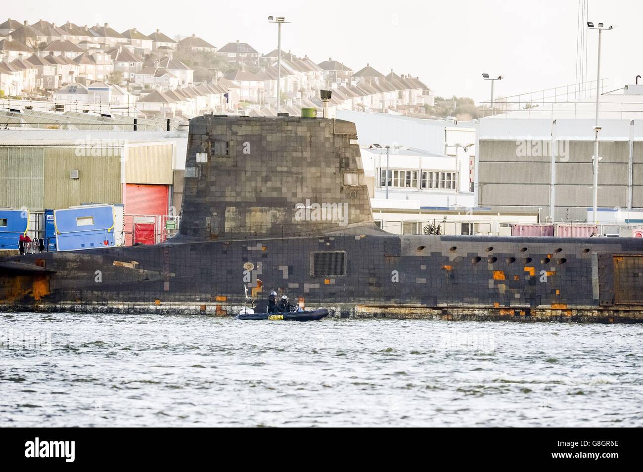 Police patrol around HMS Vanguard, one of the UK's nuclear deterrent V-Class submarines, as it is docked at Devonport, Plymouth, having a refit, estimated at &Acirc;&pound;200m. Stock Photo