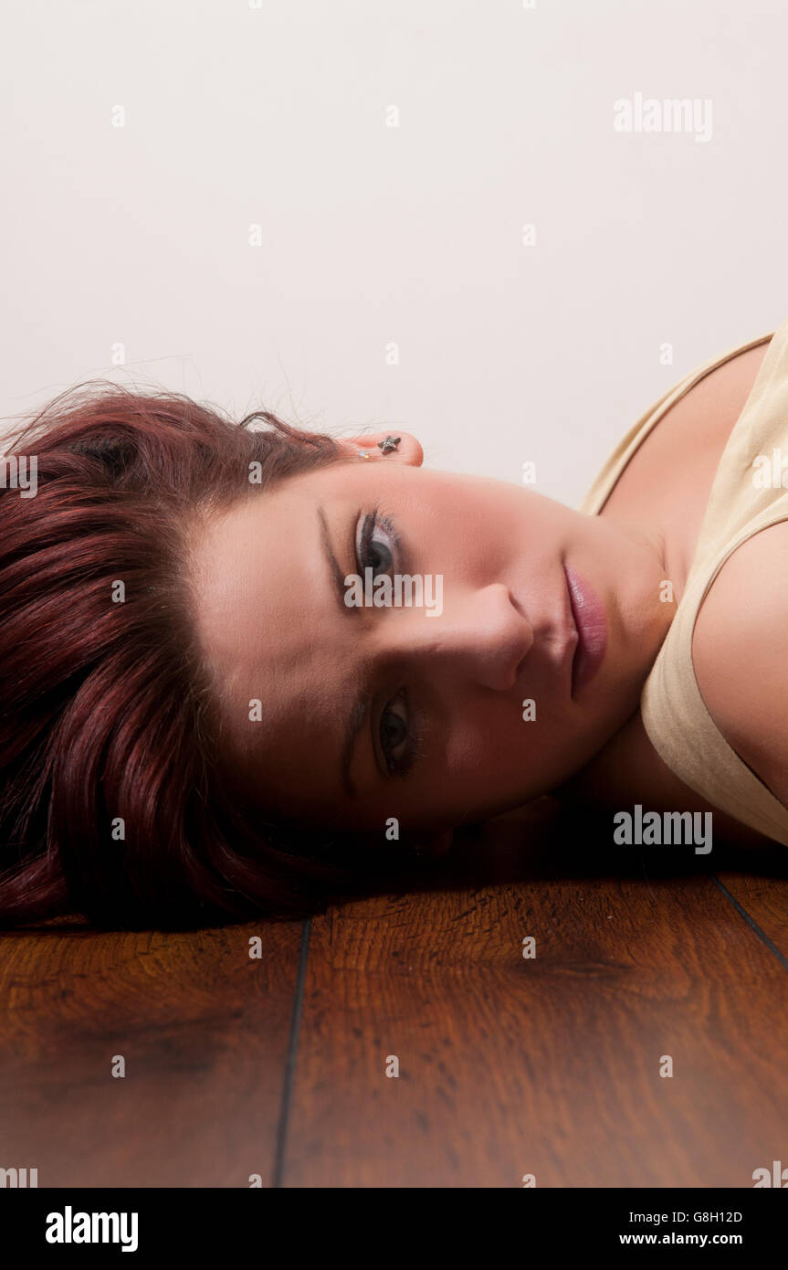 Depressed woman laying on the floor Stock Photo