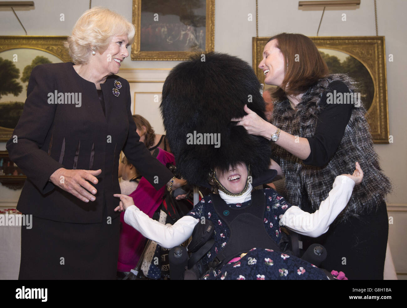 Alice Melville-Ross (12) tries on a Guard's bearskin hat at Clarence