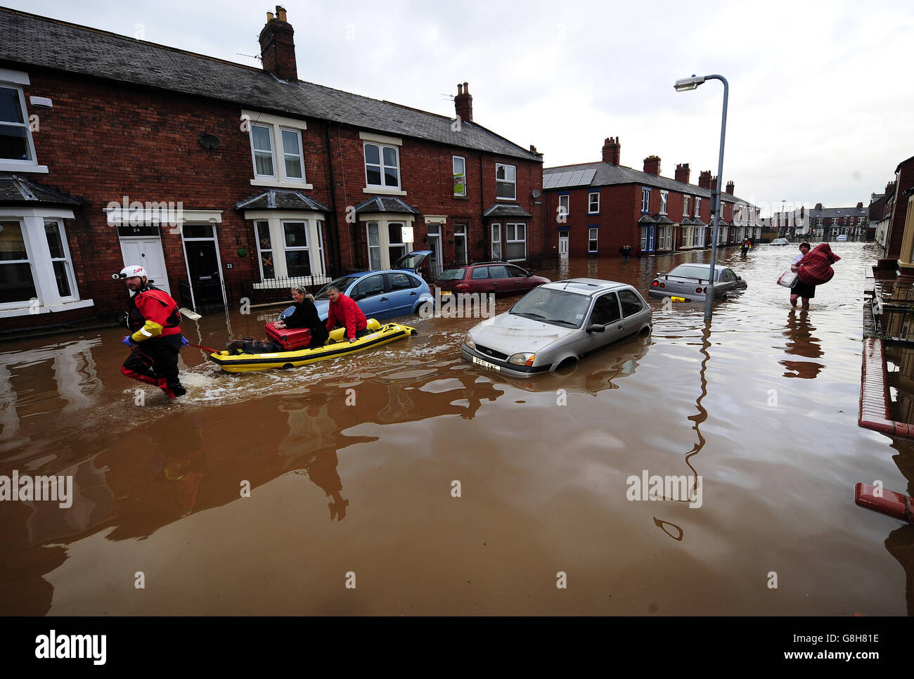 Fire and Rescue teams continue their work to bring people out of flooded homes in Carlisle as others carry what possessions they can through flooded streets. Stock Photo