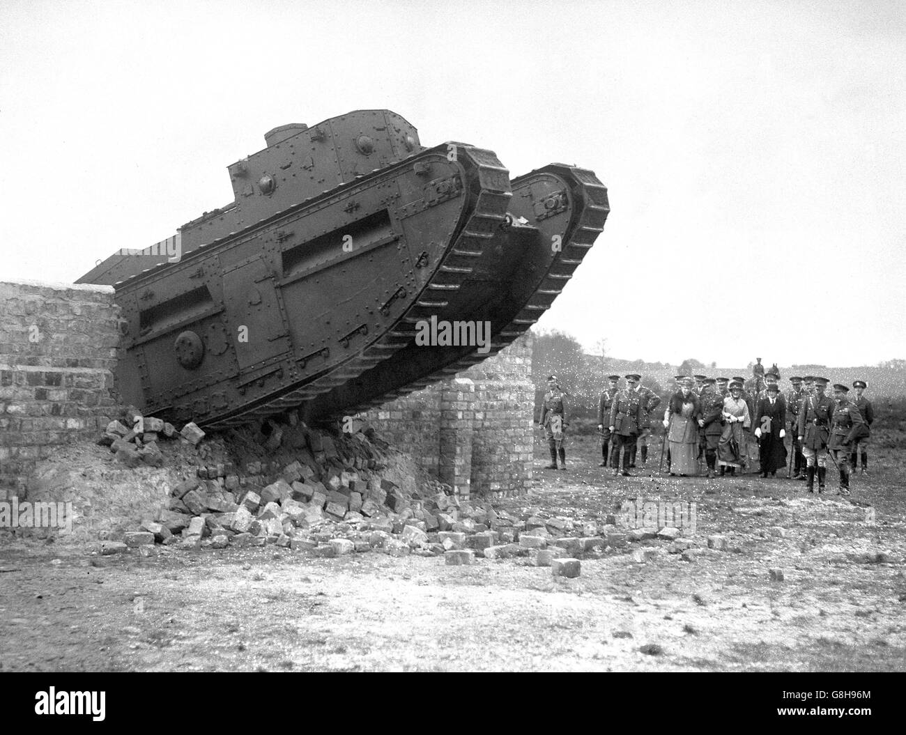 King George V watches a tank go through a brick wall when he witnessed field operations by infantry at Foresters Hill, Aldershot. Stock Photo