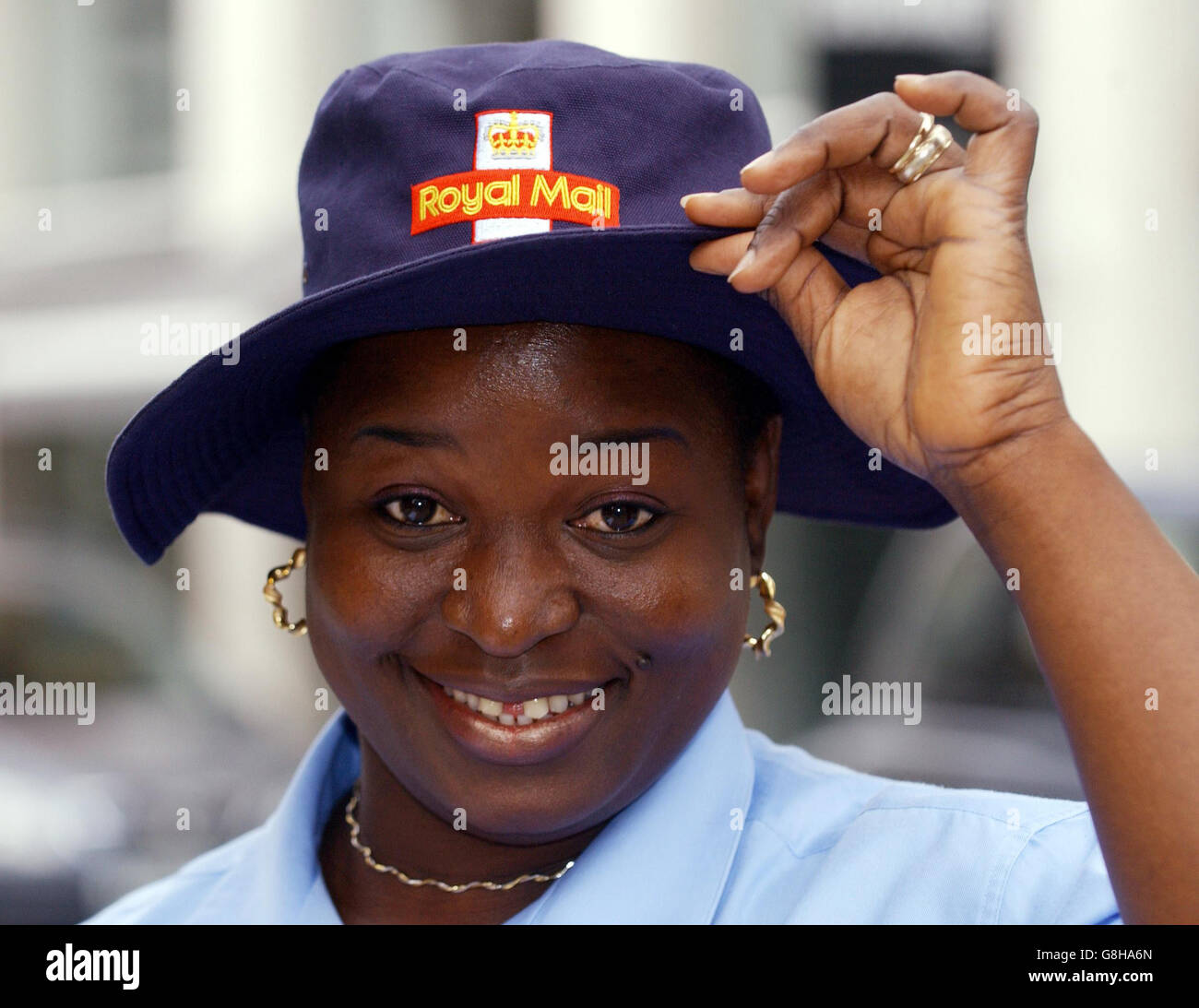 St John's Wood postwoman Tayo Falowo, wearing the new summer issue hat for postal workers whilst on her London round. Thousands of postal workers will be given a head start today in the battle to keep the sun out of their eyes on their delivery rounds with the introduction of a new hat. The blue-coloured, wide brimmed hats resemble those worn by cricketers. Stock Photo