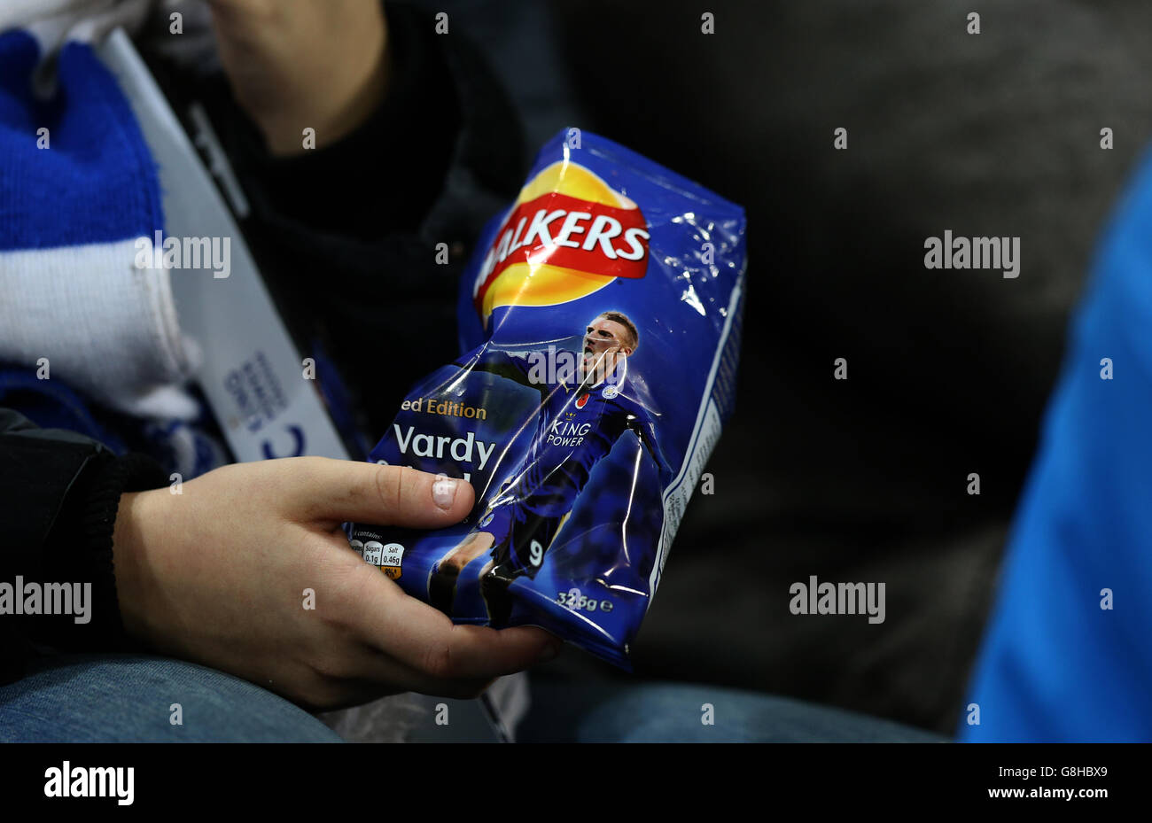 A fan eats limited edition "Vardy Salted" Walkers crisps prior to the