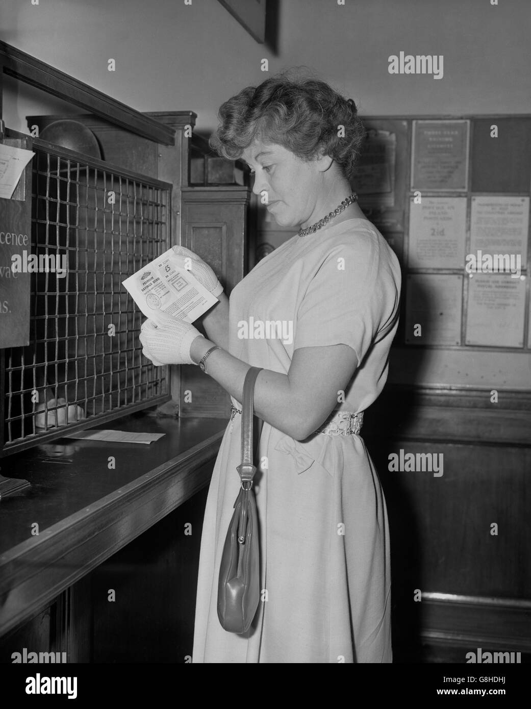 Ilford housewife Doris Williams as she buys the first of the new Series B Premium Savings Bonds at the Leicester Square Post Office in London. Stock Photo