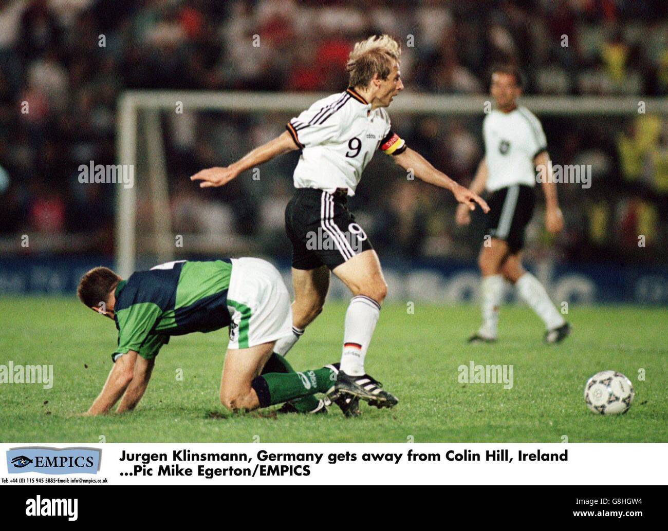 Jurgen Klinsmann of Germany (centre) gets away from Colin Hill of Northern Ireland (left) Stock Photo
