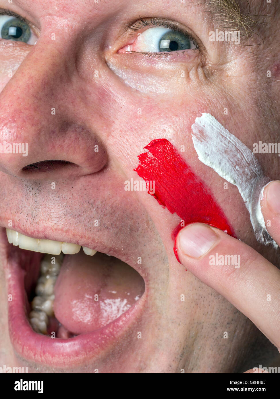 Closeup of young Polish supporter face painted with national flag colors Stock Photo