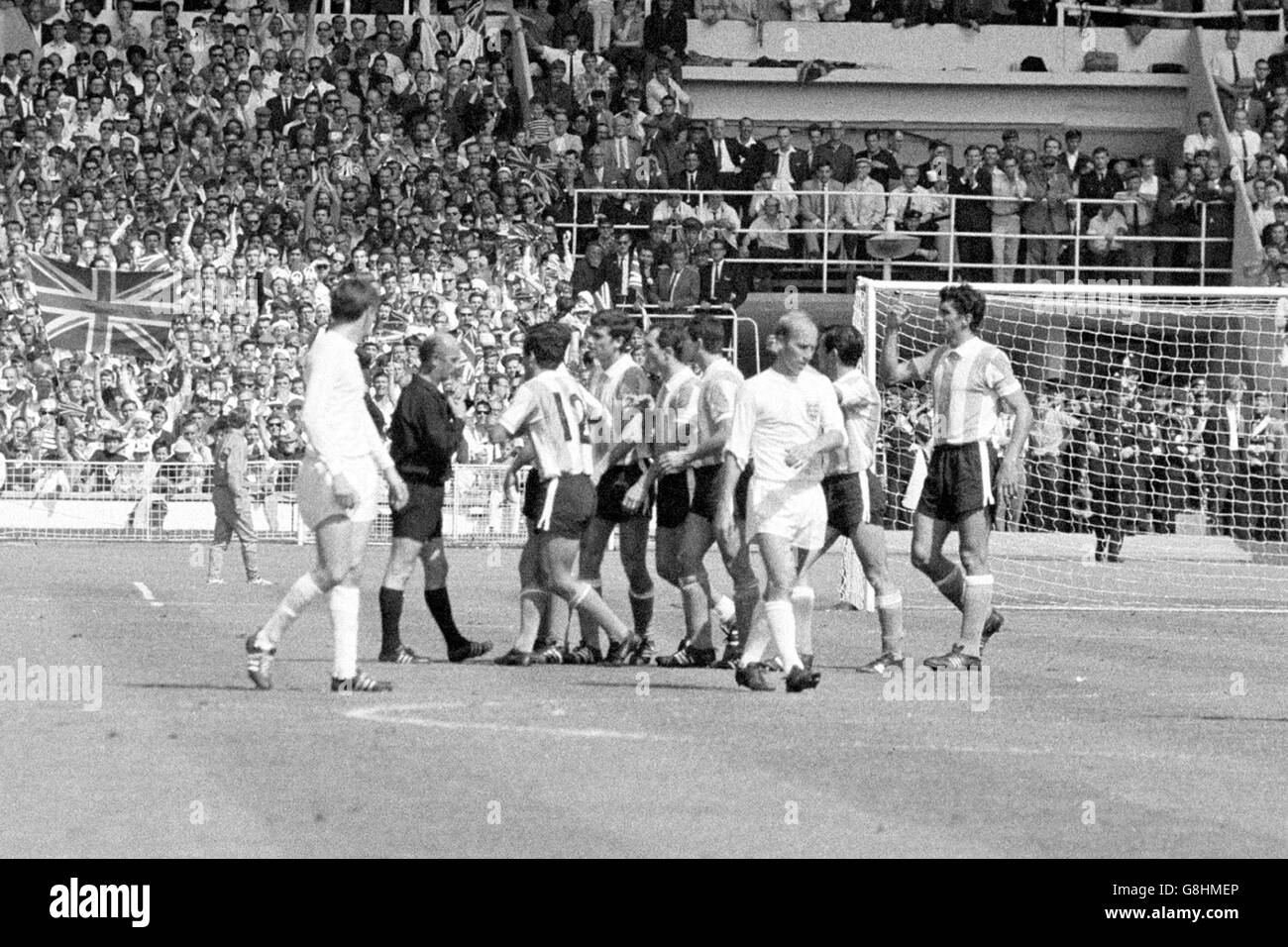Argentina players argue with referee Rudolf Kreitlein (second l) after he sent off captain Antonio Rattin (r) as England's Martin Peters (l) and Bobby Charlton (second r) try not to get involved Stock Photo