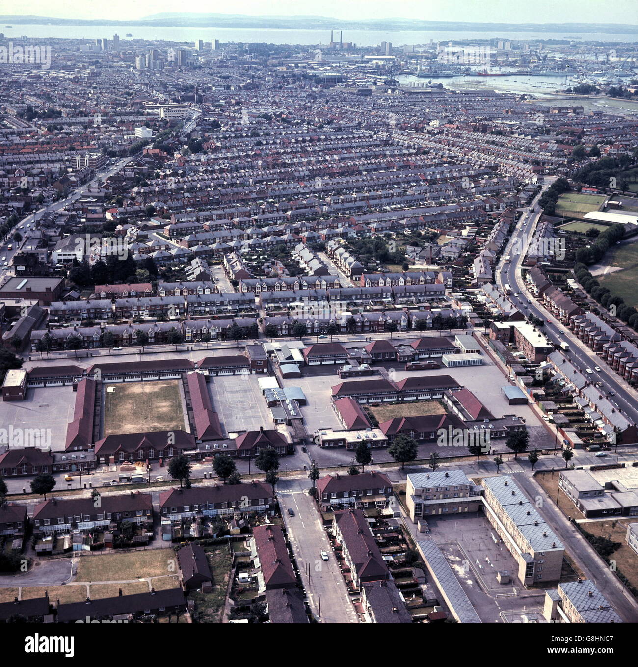 AJAXNETPHOTO. 23 JUNE, 1970. PORTSMOUTH, ENGLAND. AERIAL VIEW OF THE CITY LOOKING SOUTH WEST TOWARD THE HARBOUR. NORTH-END ROAD IS ON THE LEFT. TOWERS OF THE OLD SOUTHSEA POWER STATION ARE VISIBLE DISTANT TOP.  PHOTO:JONATHAN EASTLAND/AJAX  REF:C7009 1A Stock Photo