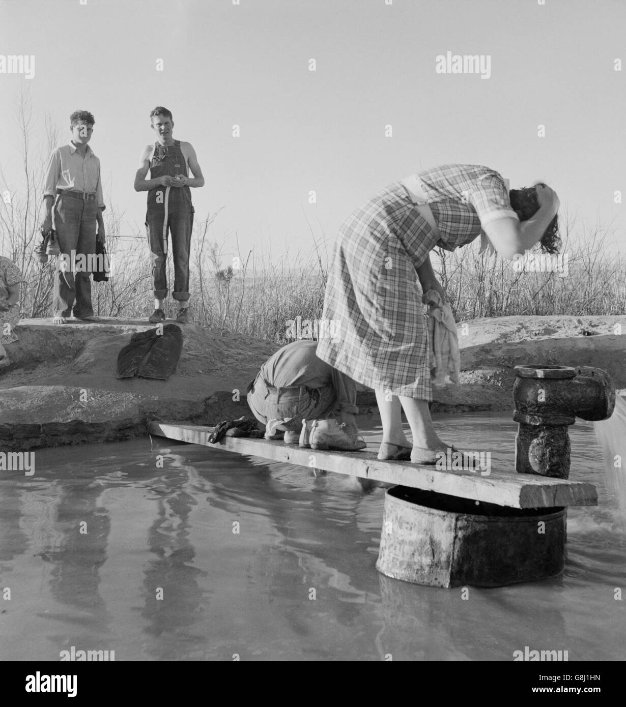 Oklahoma Migratory Workers Washing in Hot Spring in Desert, Imperial Valley, California, USA, Dorothea Lange for Farm Security Administration, March 1937 Stock Photo