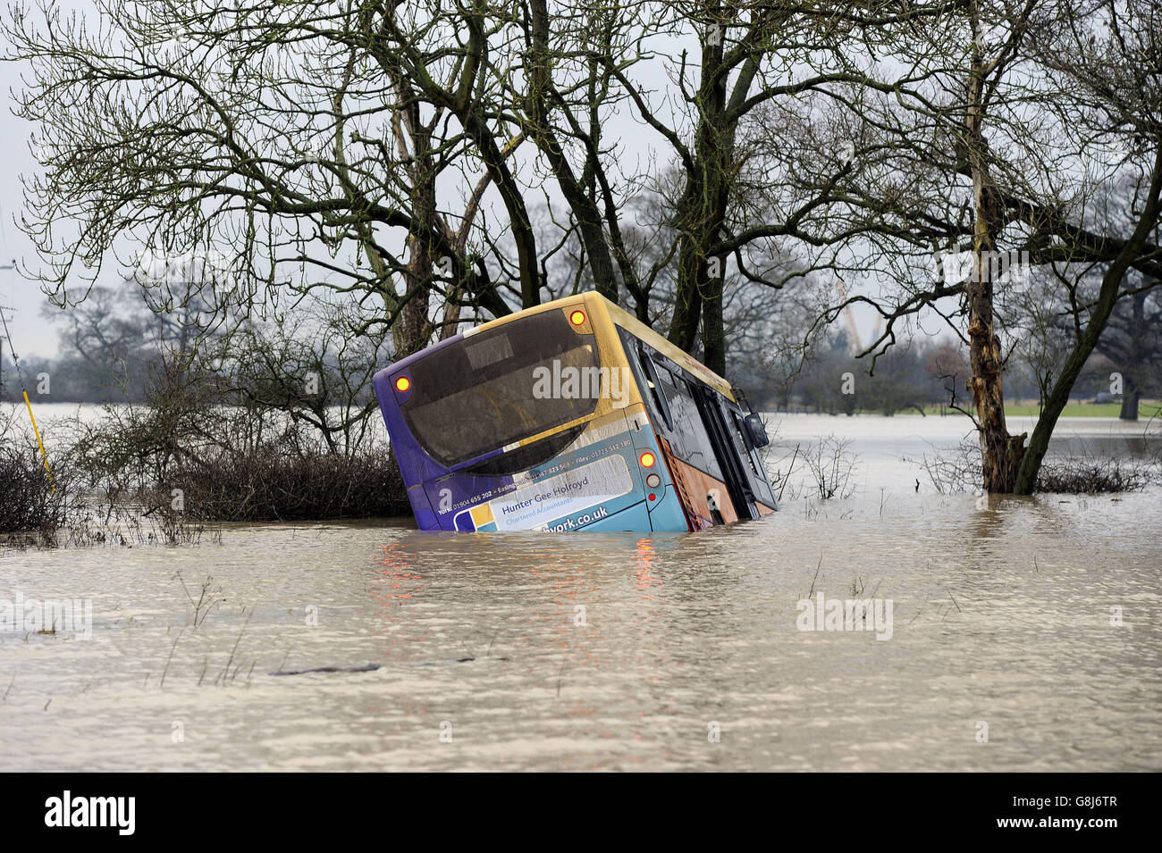 A bus swept off the road by floodwater between Newton-on-Ouse and Tollerton, north of York. Stock Photo