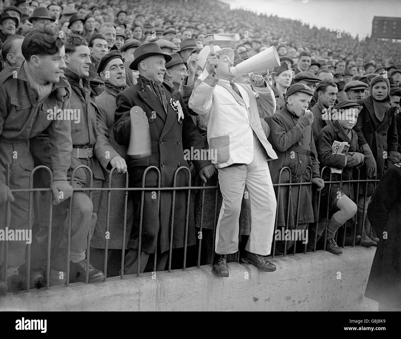 A Preston North End fan tries to out-shout the thousands of Charlton Athletic supporters standing behind him Stock Photo