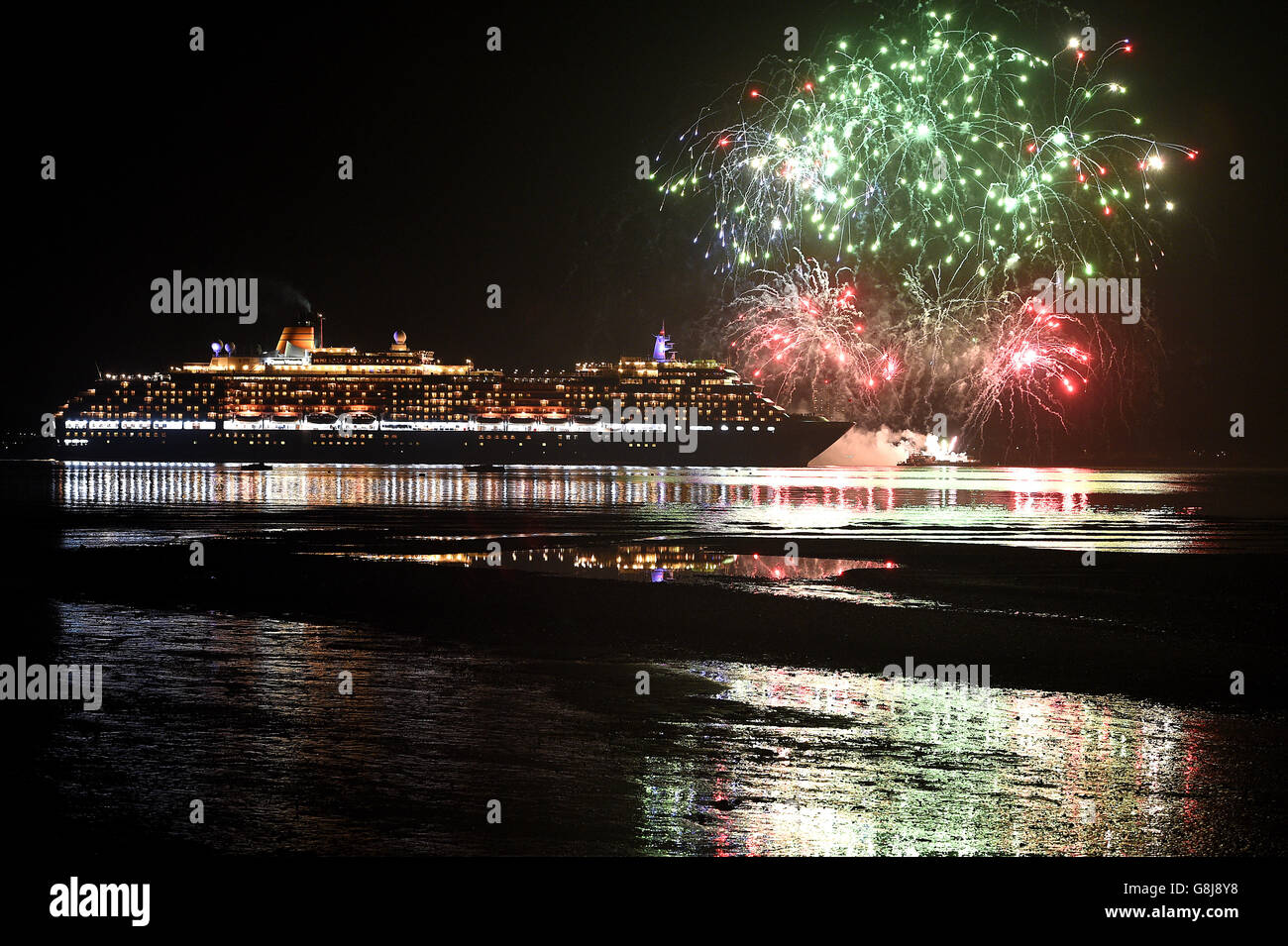 Fireworks are let off as Cunard's Queen Victoria, one of the Three Queens liners, makes her way down Southampton water into the River Solent on her first world voyage of 2016. Stock Photo