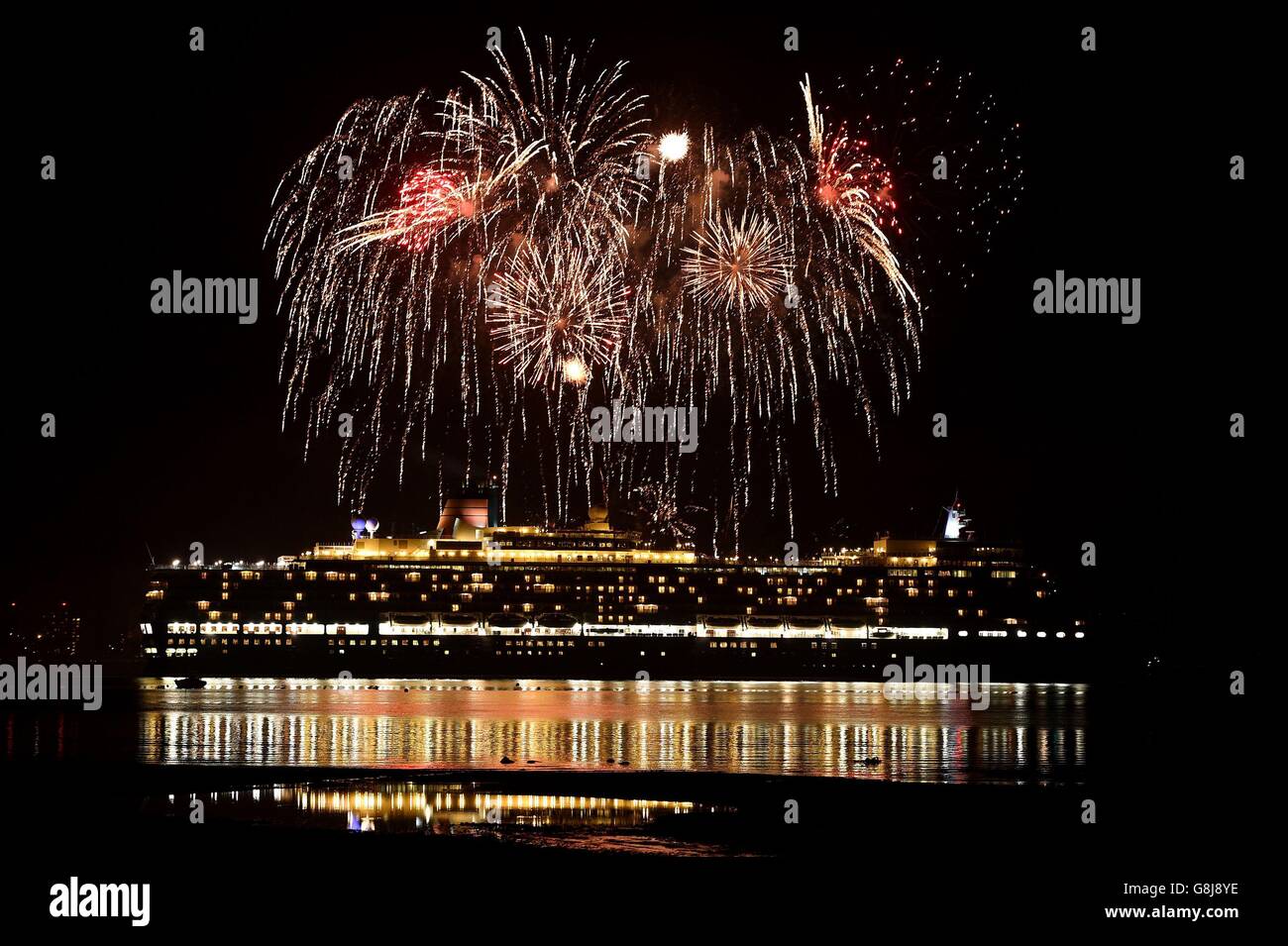 Fireworks are let off as Cunard's Queen Elizabeth, one of the Three Queens liners, makes her way down Southampton water into the River Solent on her first world voyage of 2016. Stock Photo