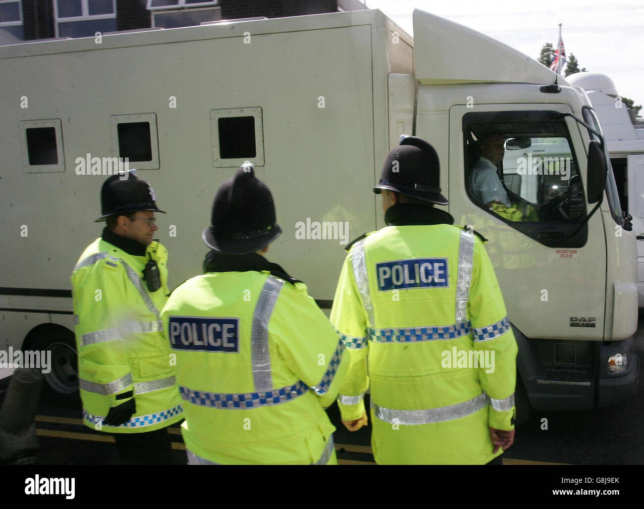 Police officers escort a security van as it leaves Knowsley Magistrates