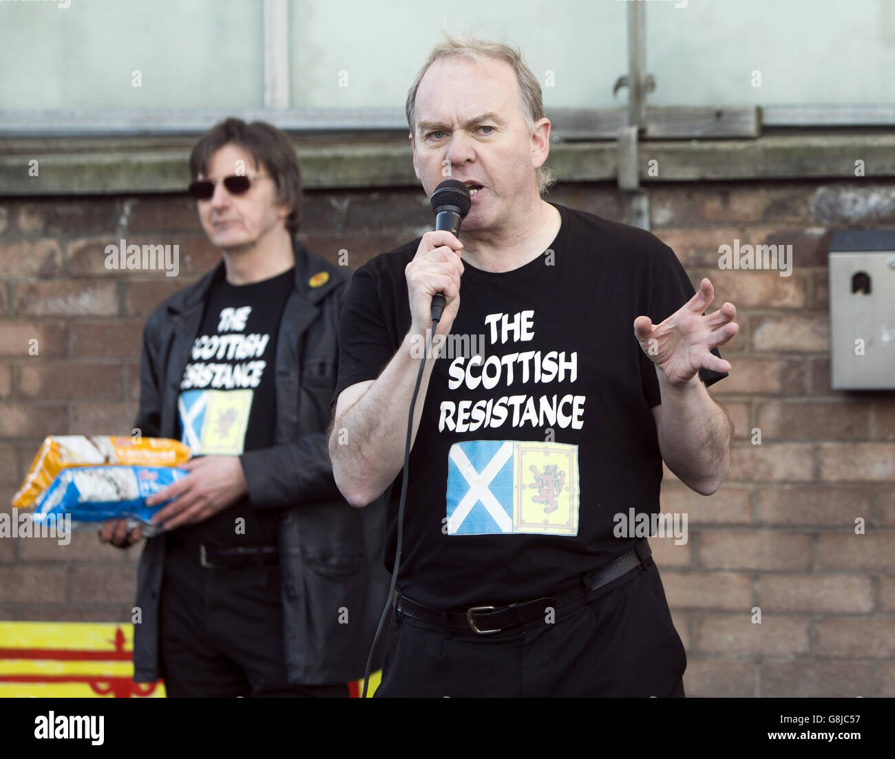 Activists Sean Clerkin (right) and James Scott from the Scottish Resistance group take part in a protest outside Tunnock's factory in Uddingston, Lanarkshire, a week after the firm advertised its best-selling biscuit as the Great British Tea Cake. Stock Photo