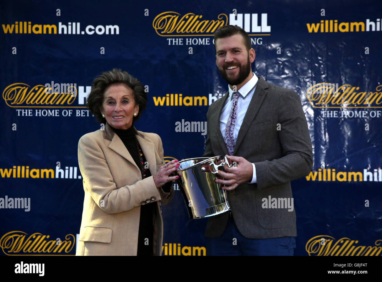 A representative of John Stone receives the trophy on his behalf after Baron Alco won the William Hill World Darts Championship Handicap Hurdle Stock Photo