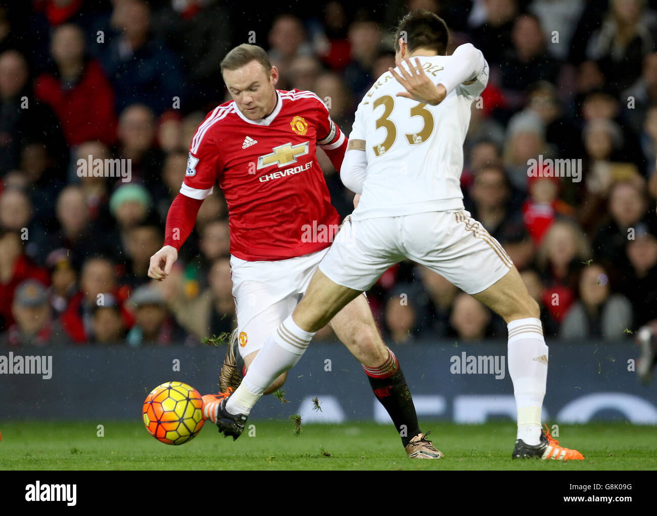 Manchester United v Swansea City - Barclays Premier League - Old Trafford. Swansea City's Federico Fernandez trips Manchester United's Wayne Rooney Stock Photo