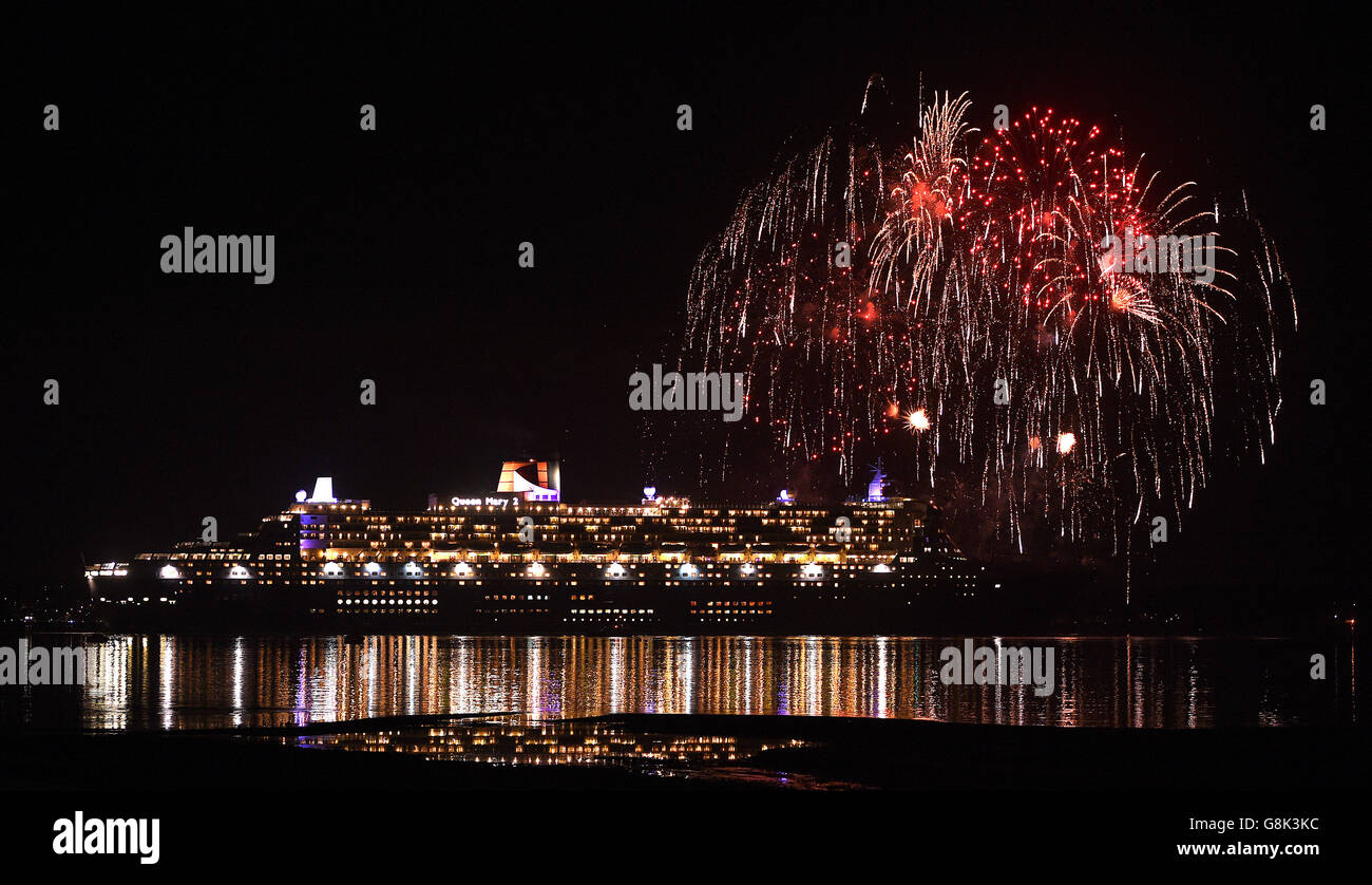 Fireworks are let off as Cunard's Queen Mary 2, one of the Three Queens liners, makes her way down Southampton water into the River Solent on her first world voyage of 2016. Stock Photo