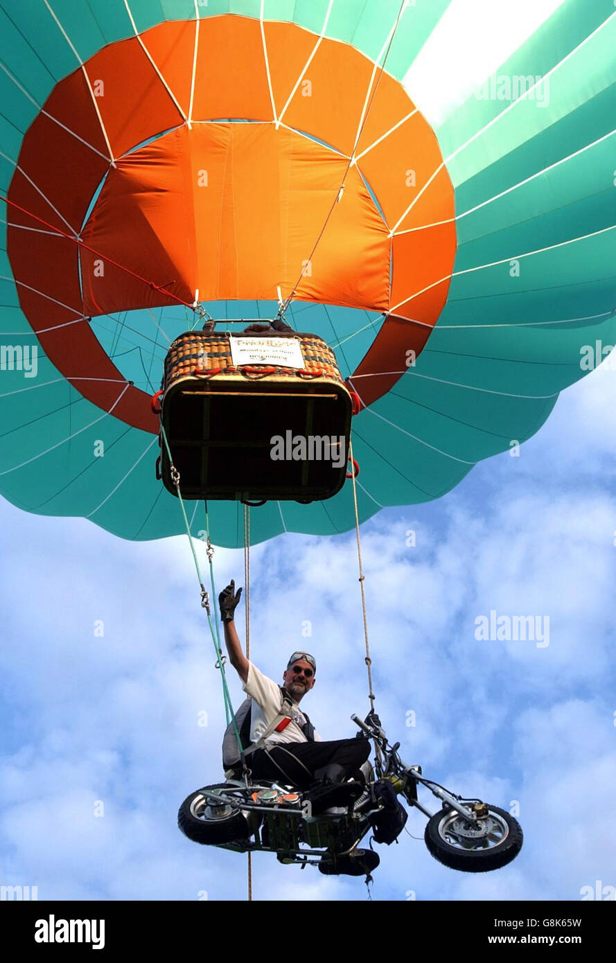 Ian Ashpole prepares to jump from his specially customised chopper style  motorbike that will be suspended under a hot air balloon from a height of  3,000 feet over Ashton Court Stock Photo -