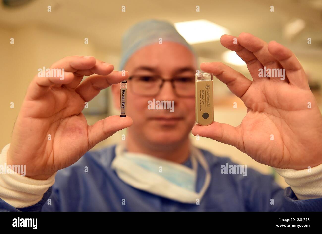 Poole Hospital Consultant Cardiologist Dr Christopher Boos holds up a demo version of a Reveal LINQ Cardiac Heart Monitor (left) alongside an older Reveal XT which it has replaced. The new monitor will be inserted into into a group of the British armed forces who will be taking part in a 1-2 month mountain climb of the 6920m Tukuche peak in Nepal, and the 8000m Dhaulagiri massif - the 7th highest mountain in the world. Stock Photo