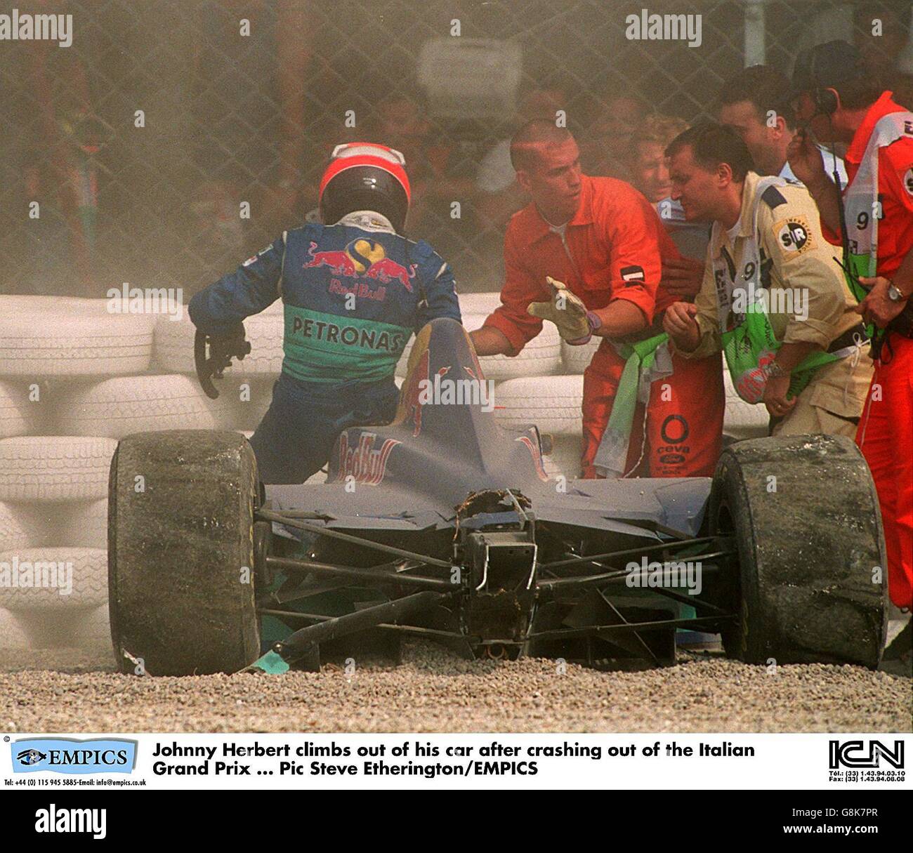 Johnny Herbert (left) climbs out of his car after crashing out of the Italian Grand Prix Stock Photo
