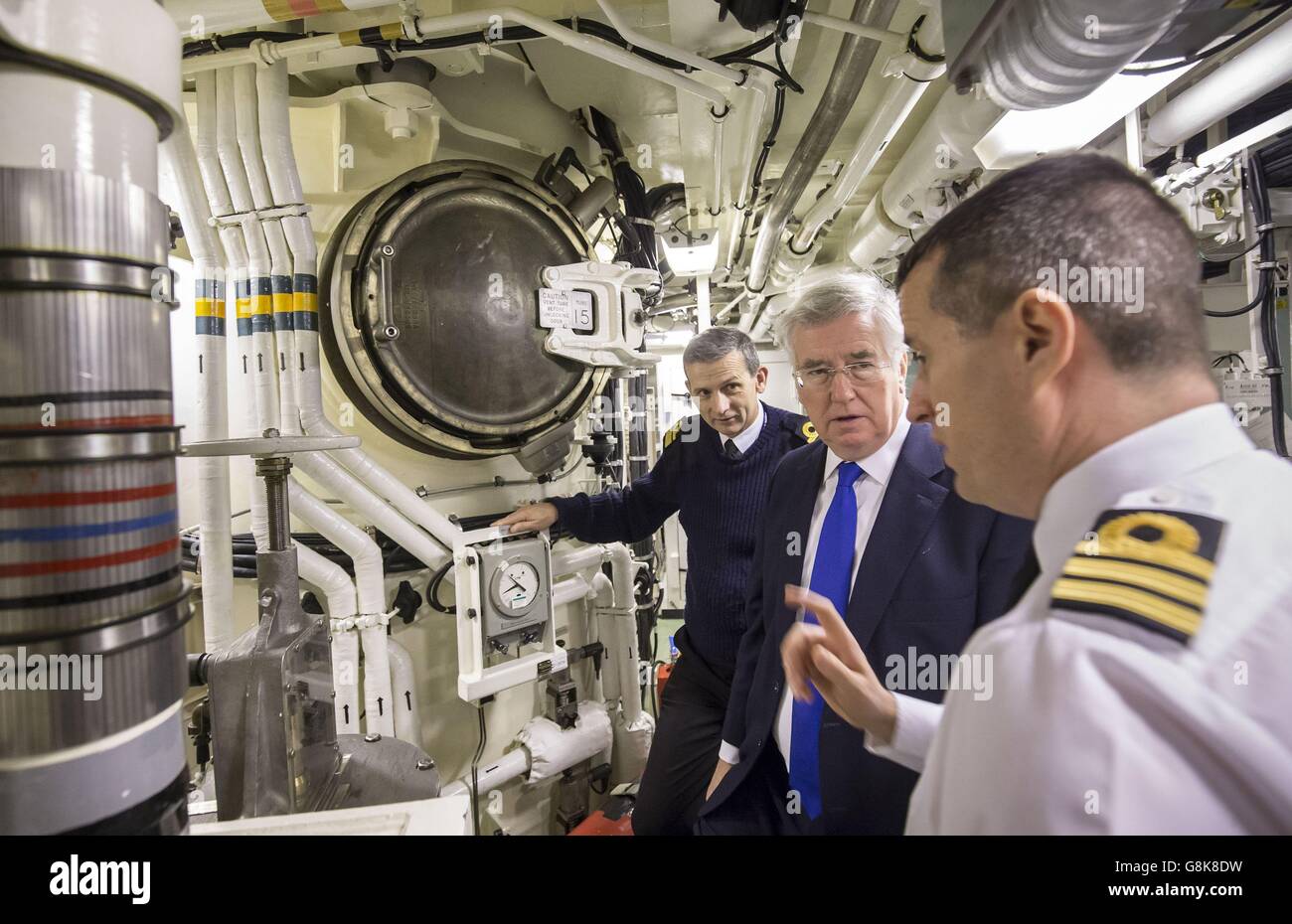 Defence Secretary Michael Fallon (centre) with Rear Admiral of Submarines and Assistant Chief of Naval Staff John Weale (left) and Daniel Martyn (right) Commanding Officer of HMS Vigilant in the missiles compartment that can house up to 16 Trident 2 D5 nuclear missiles, during a visit to Vanguard-class submarine HMS Vigilant, one of the UK's four nuclear warhead-carrying submarines, at HM Naval Base Clyde, also known as Faslane, in Scotland. Stock Photo