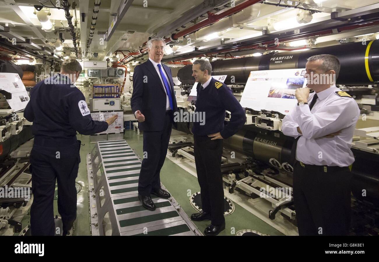 Defence Secretary Michael Fallon (centre) with Rear Admiral of Submarines and Assistant Chief of Naval Staff John Weale (second right) and Daniel Martyn (right) Commanding Officer of HMS Vigilant in the weapons storage compartment during a visit to Vanguard-class submarine HMS Vigilant, one of the UK's four nuclear warhead-carrying submarines, at HM Naval Base Clyde, also known as Faslane, in Scotland. Stock Photo
