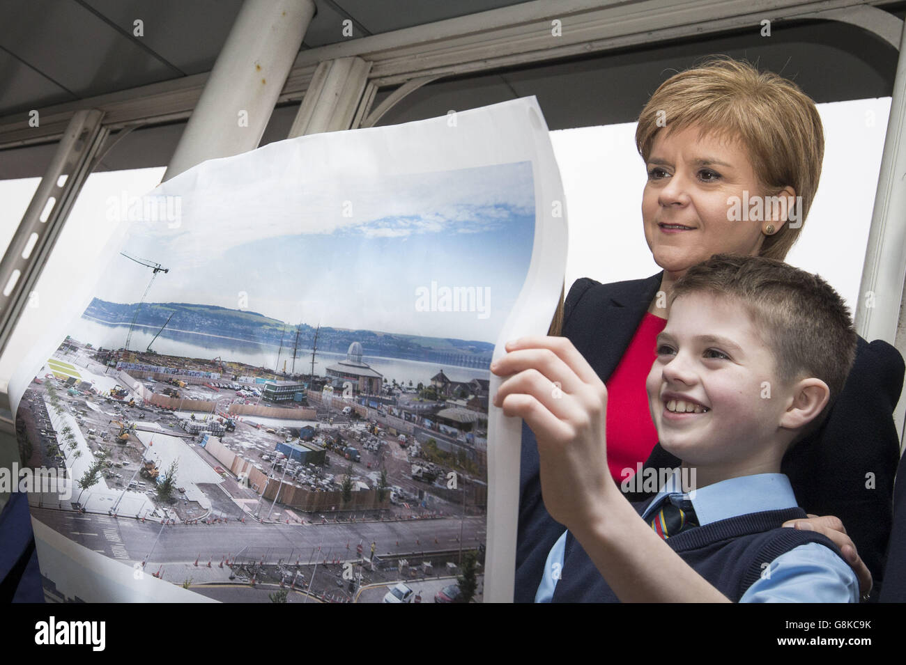 First Minister Nicola Sturgeon and St Mary's Primary School pupil Zane Bell look at photographs of the Waterfront regeneration project during a visit to Discovery Point in Dundee, Scotland. Stock Photo