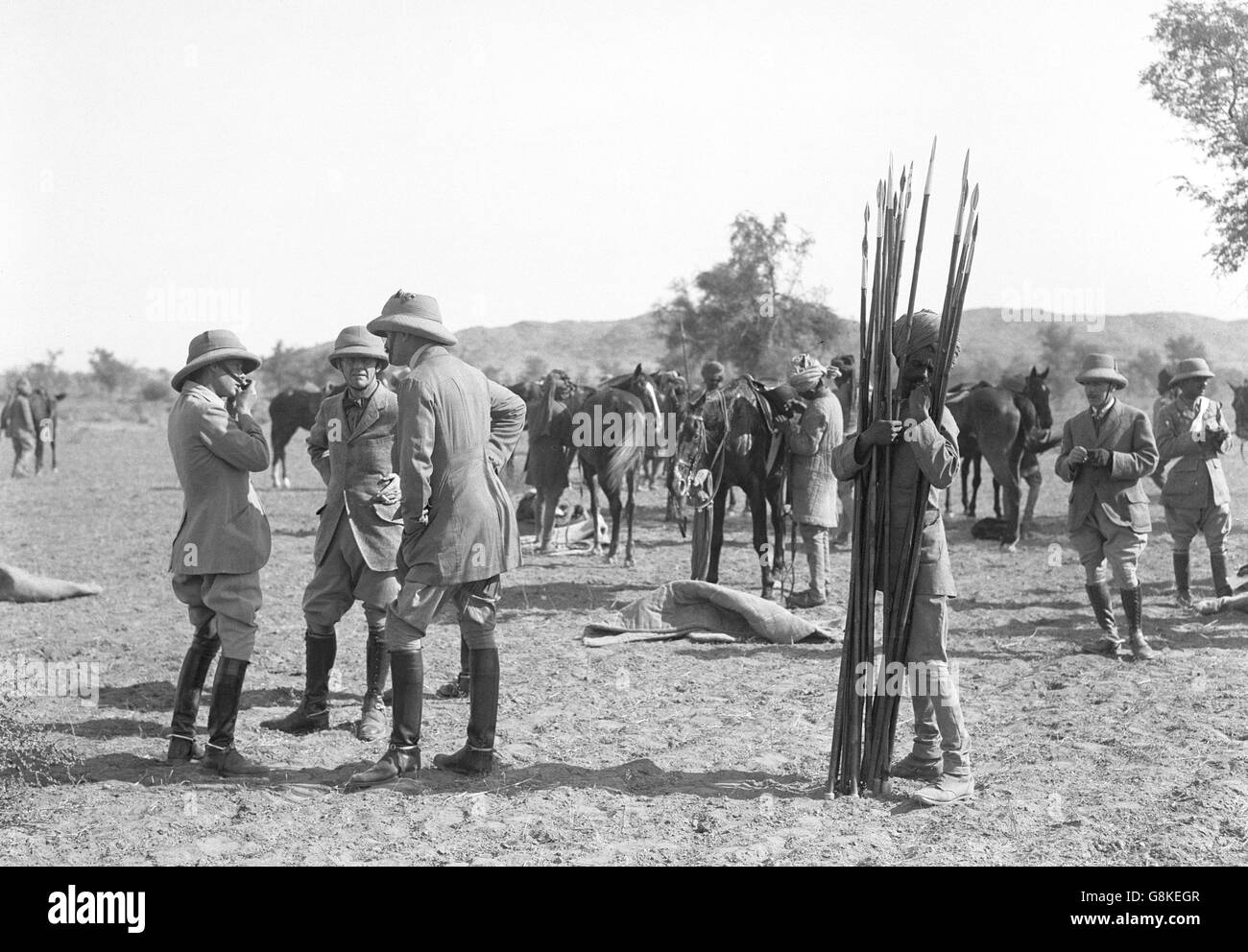 The Prince of Wales tries out pigsticking in Jodhpur. On the right, a native attendant stands by with a selection of spears. Stock Photo