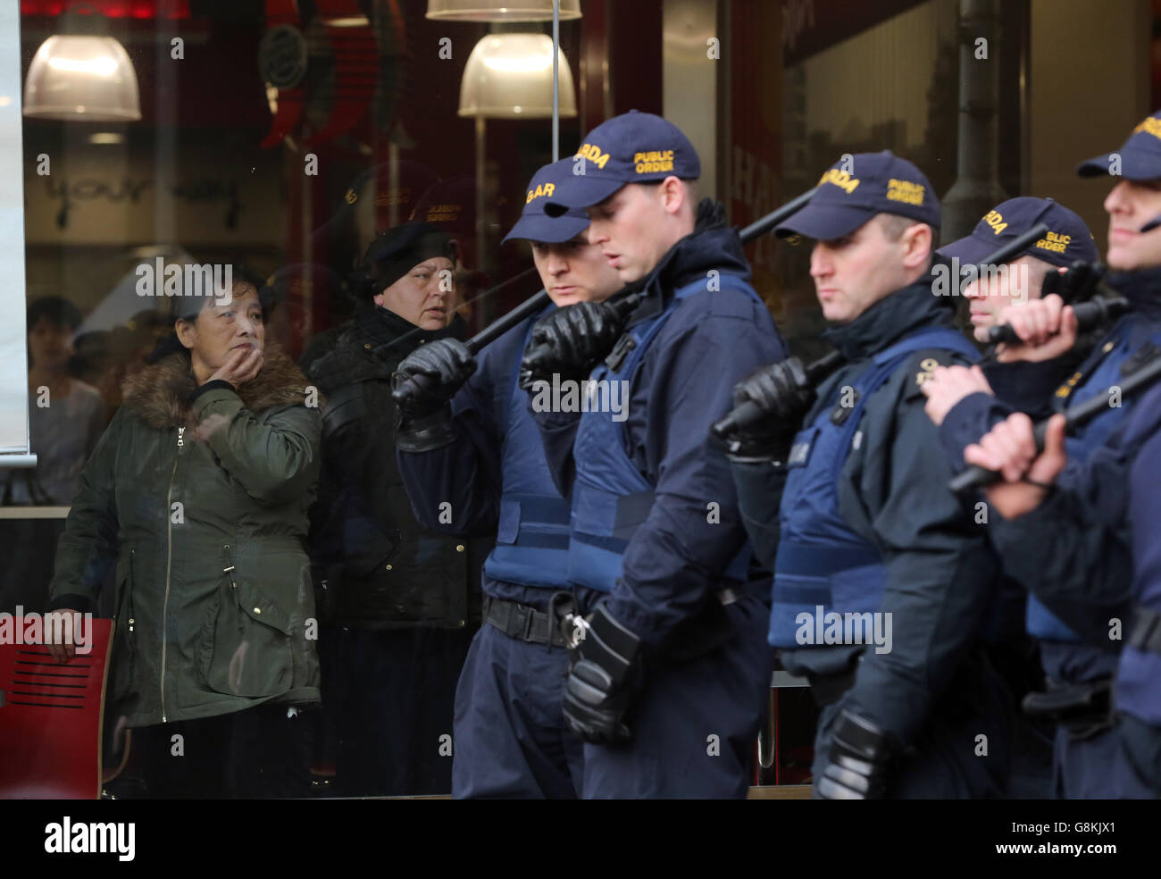 Patrons look on from inside a Burger King restaurant in Dublin city centre as members of the Garda Public Order Unit confront anti-racism protesters during a counter demonstration against the launch of an Irish branch of Pegida, the far-right movement from Germany. Stock Photo