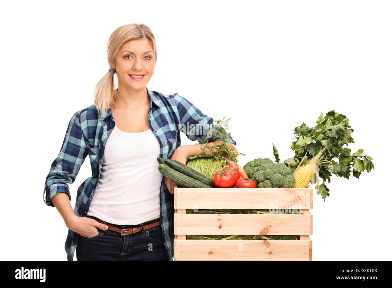 Female agricultural worker posing next to a crate full of fresh ...