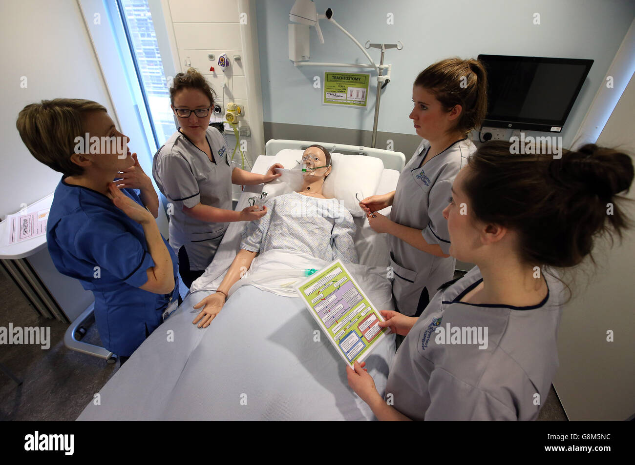 Practice Educators Kate Hill with student nurses Martha Allen (second left), Fiona Bruce (second right) and Claire Rankine (far right) as they carry out a tracheostomy medical scenario using a mannequin in the Alexander Fairley Clinical Skills Area at the Queen Elizabeth University Hospital in Glasgow. Stock Photo