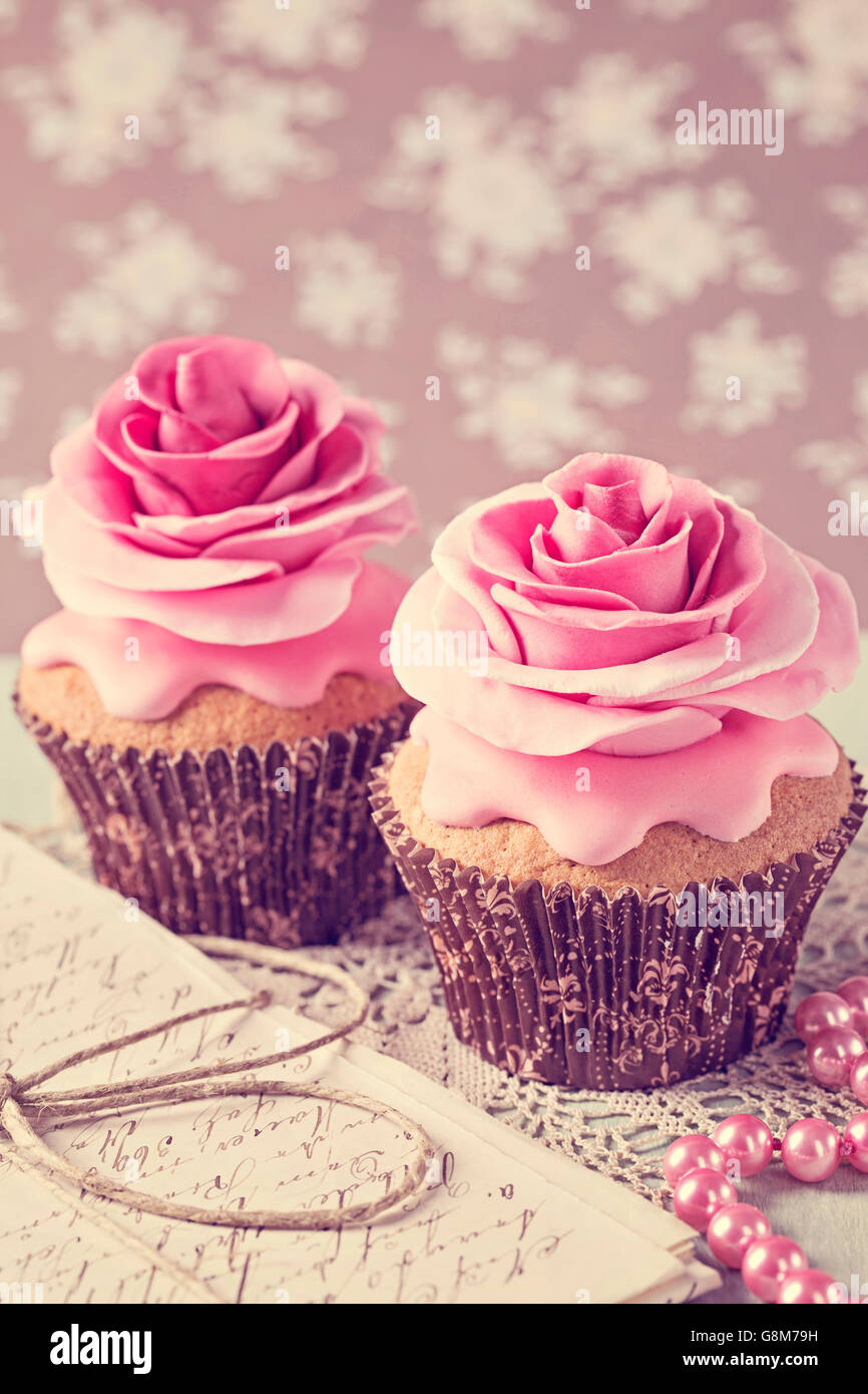 Two cupcakes with rose flowers and a letter Stock Photo