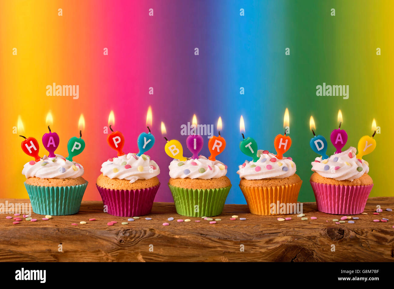 Cupcakes with candles on colorful background Stock Photo - Alamy