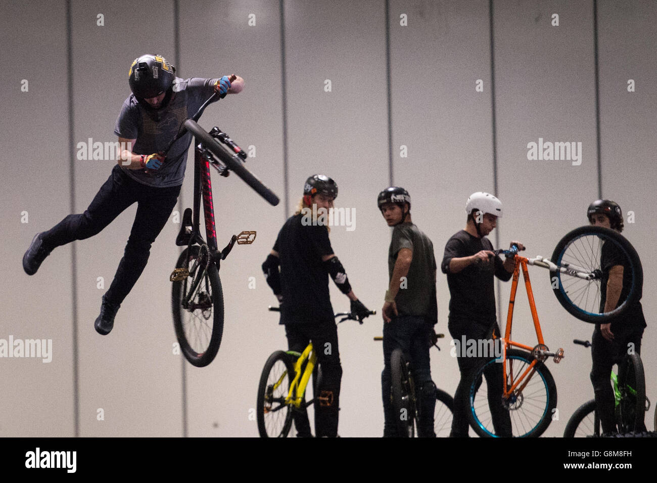 BMX riders perform stunts at the London Bike Show at the Excel centre in east London. Stock Photo