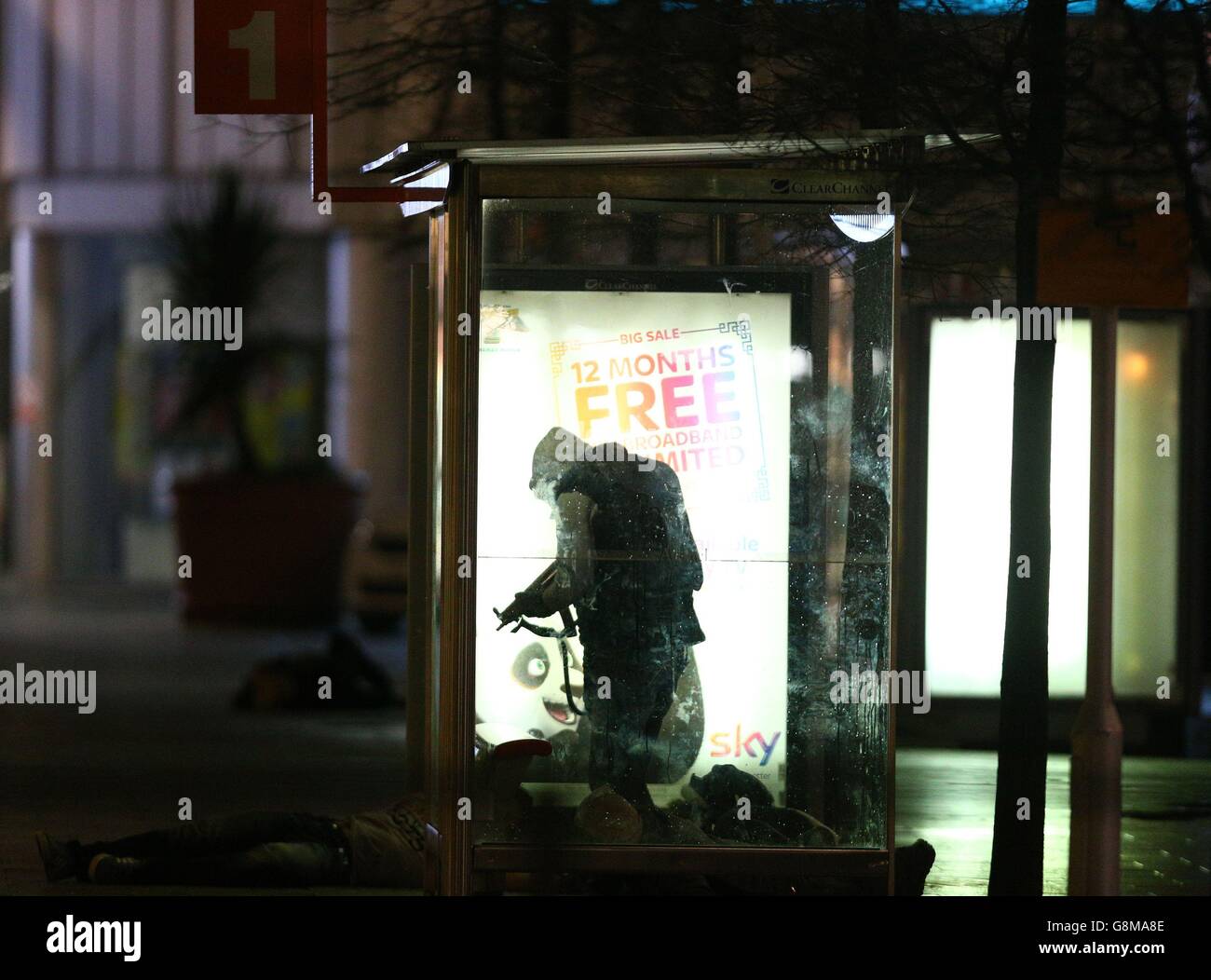 People playing the part of gunmen 'open fire' at a packed bus stop during a training exercise to test the response of the emergency services to a major firearms attack at the Intu Braehead shopping centre near Glasgow. Stock Photo