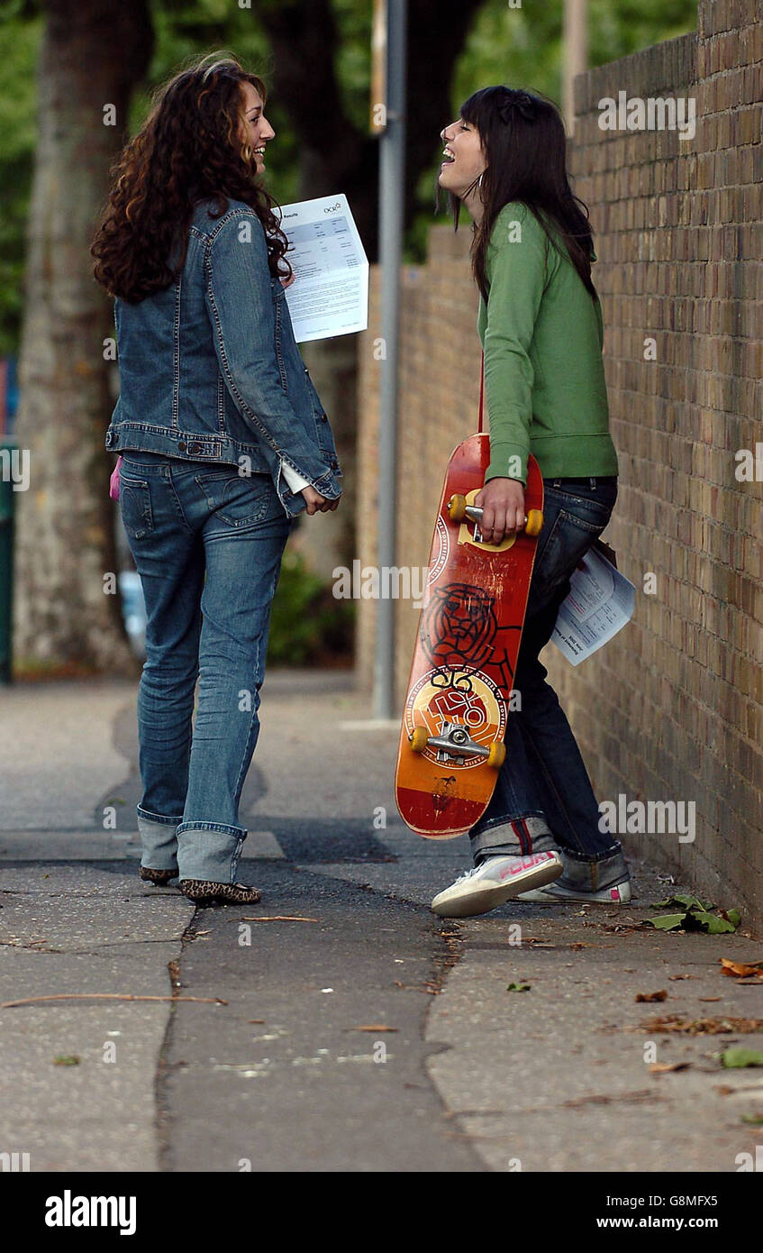 Louisa Miller, and Somayeh Jafari, (skateboard), both 16, make their way home after picking up there GCSE results from St Bernard's High School and Arts College, Southend, Essex. Stock Photo