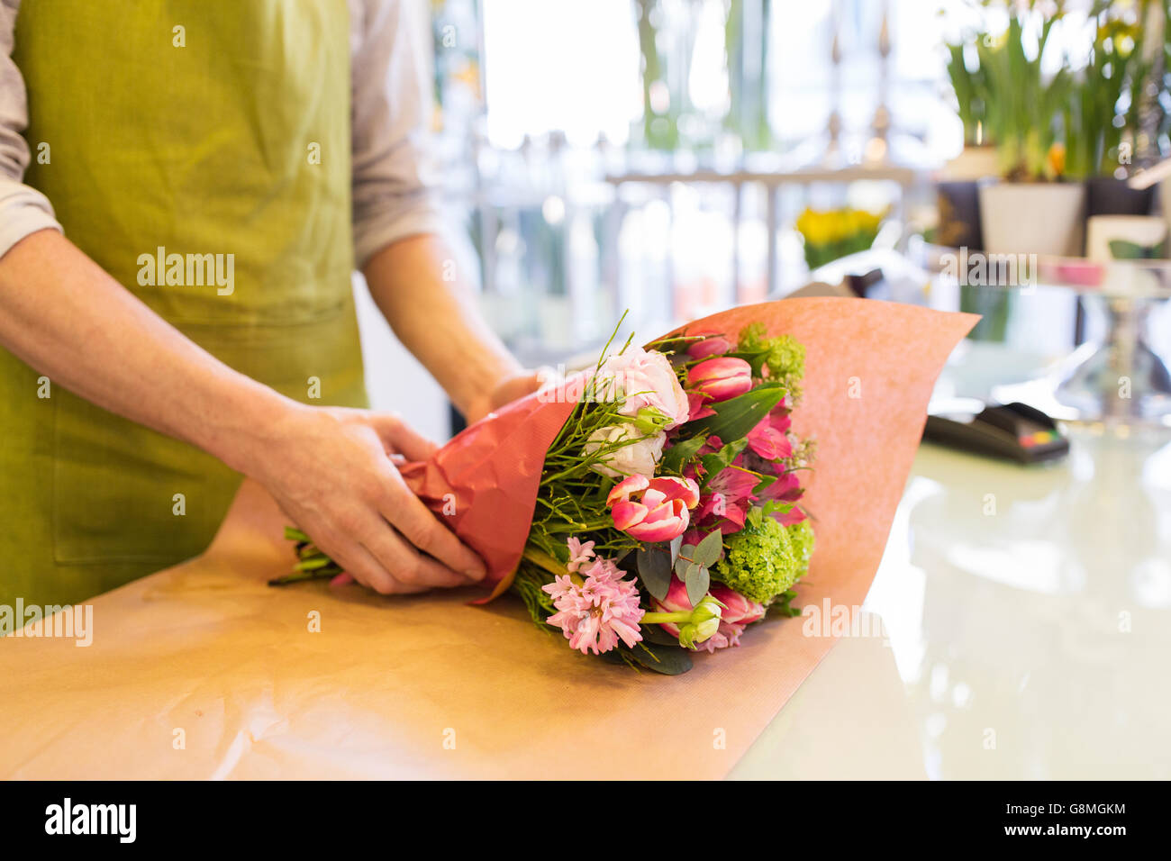 florist wrapping flowers in paper at flower shop Stock Photo Alamy