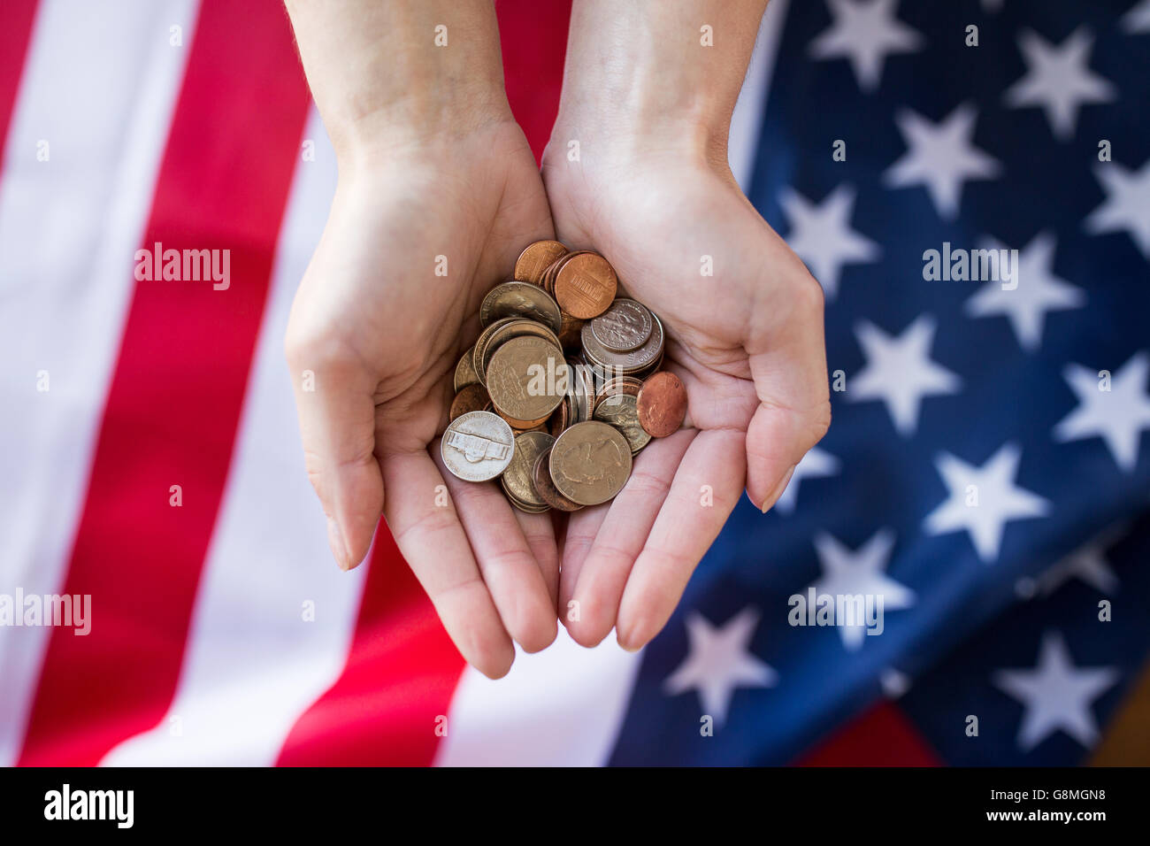 close up of hands with coins over american flag Stock Photo