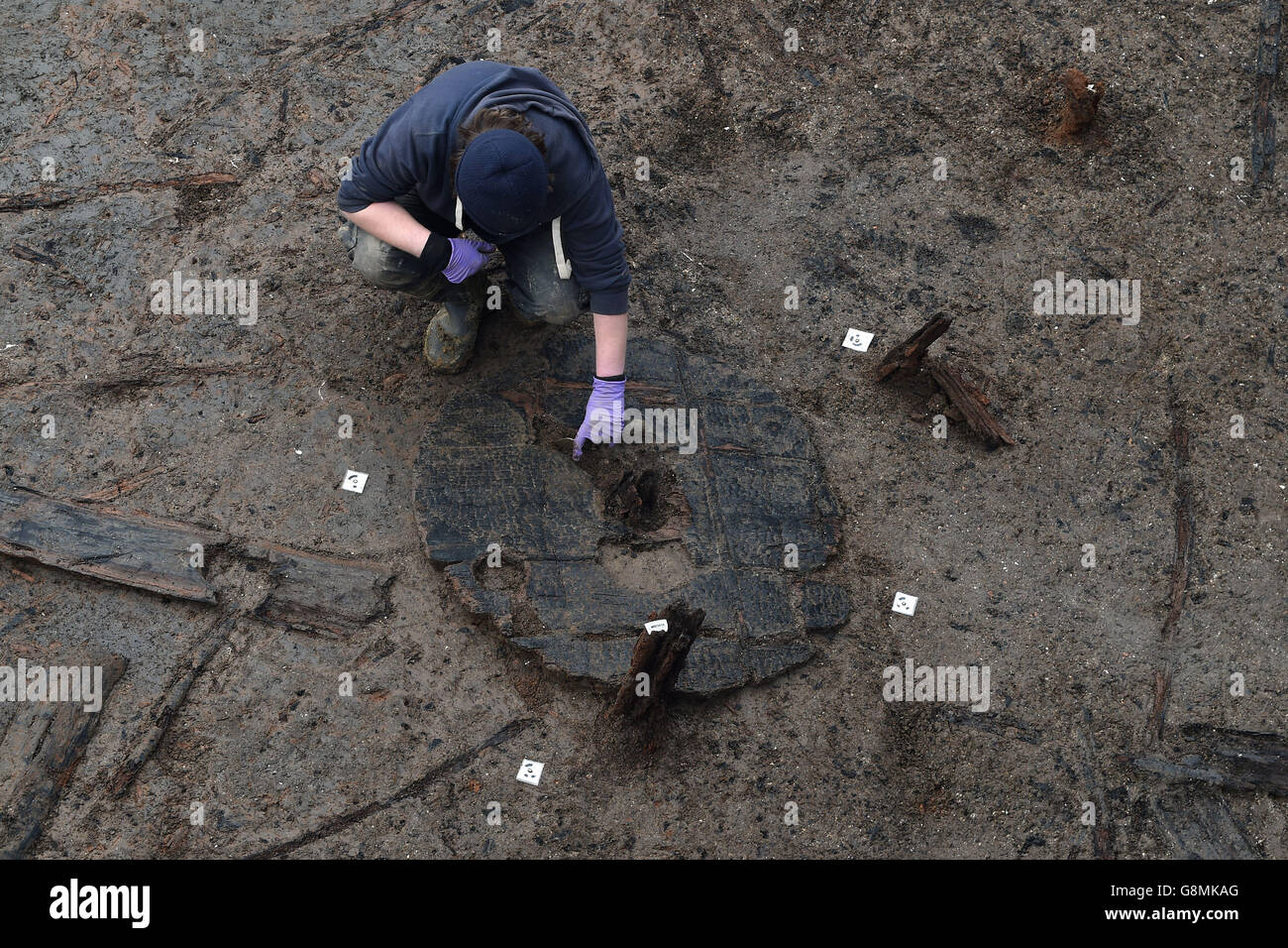 Archaeologists work to extract the earliest complete Bronze Age wheel found in Britain, dated 1100-800 BC, during the excavation of the Must Farm site near Peterborough in Cambridgeshire. Stock Photo