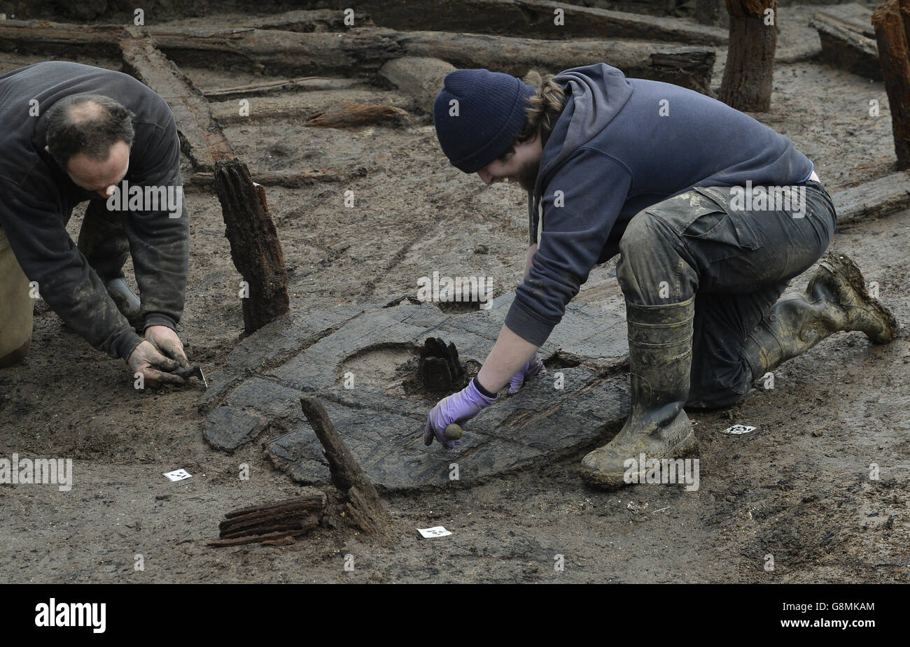 Archaeologists work to extract the earliest complete Bronze Age wheel found in Britain, dated 1100-800 BC, during the excavation of the Must Farm site near Peterborough in Cambridgeshire. Stock Photo