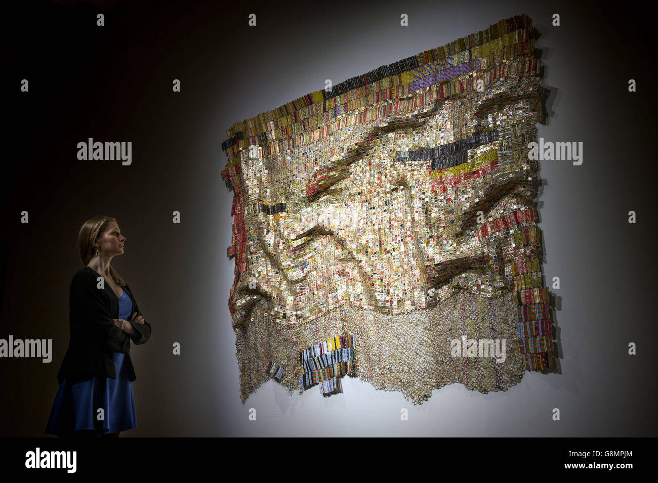 A woman views Peju's Robe by El Anatsui, estimated at between &Acirc;&pound;450,000 and &Acirc;&pound;550,000, during the press preview of Bonham's forthcoming Post-War and Contemporary Art Sale which will be held on February 11 in London. Stock Photo
