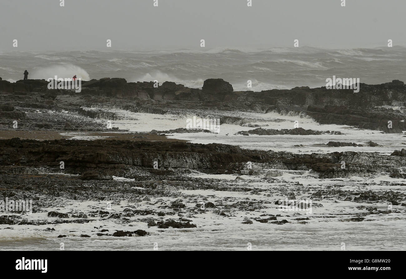 Sea foam washes up on the beach at Porthcawl in Wales as winds of