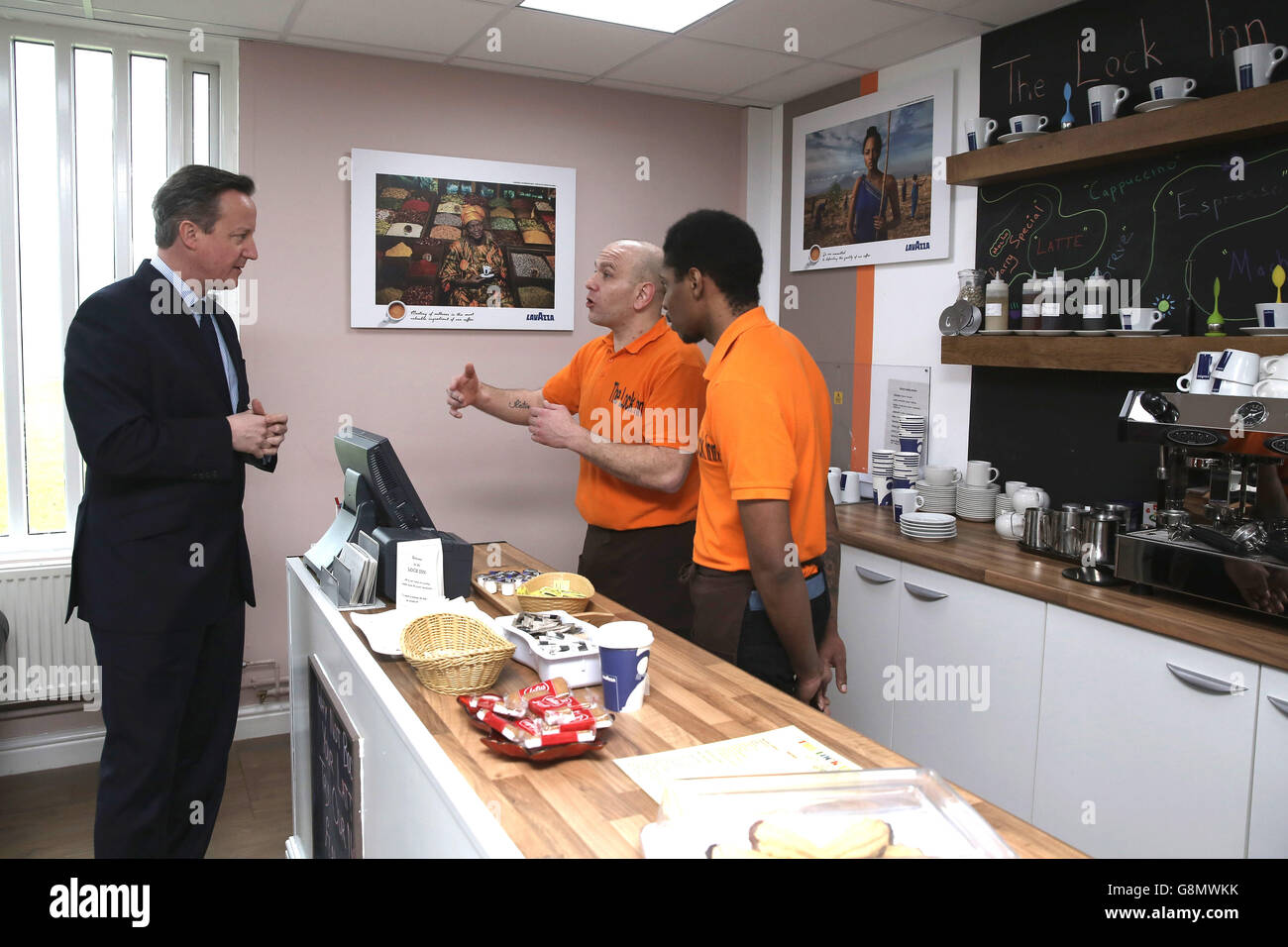 Prime Minister David Cameron talks to inmates Richard and Michael (right) inside The Lock Inn Cafe as he tours HMP Onley in Rugby ahead of a major speech on prison reform. Stock Photo