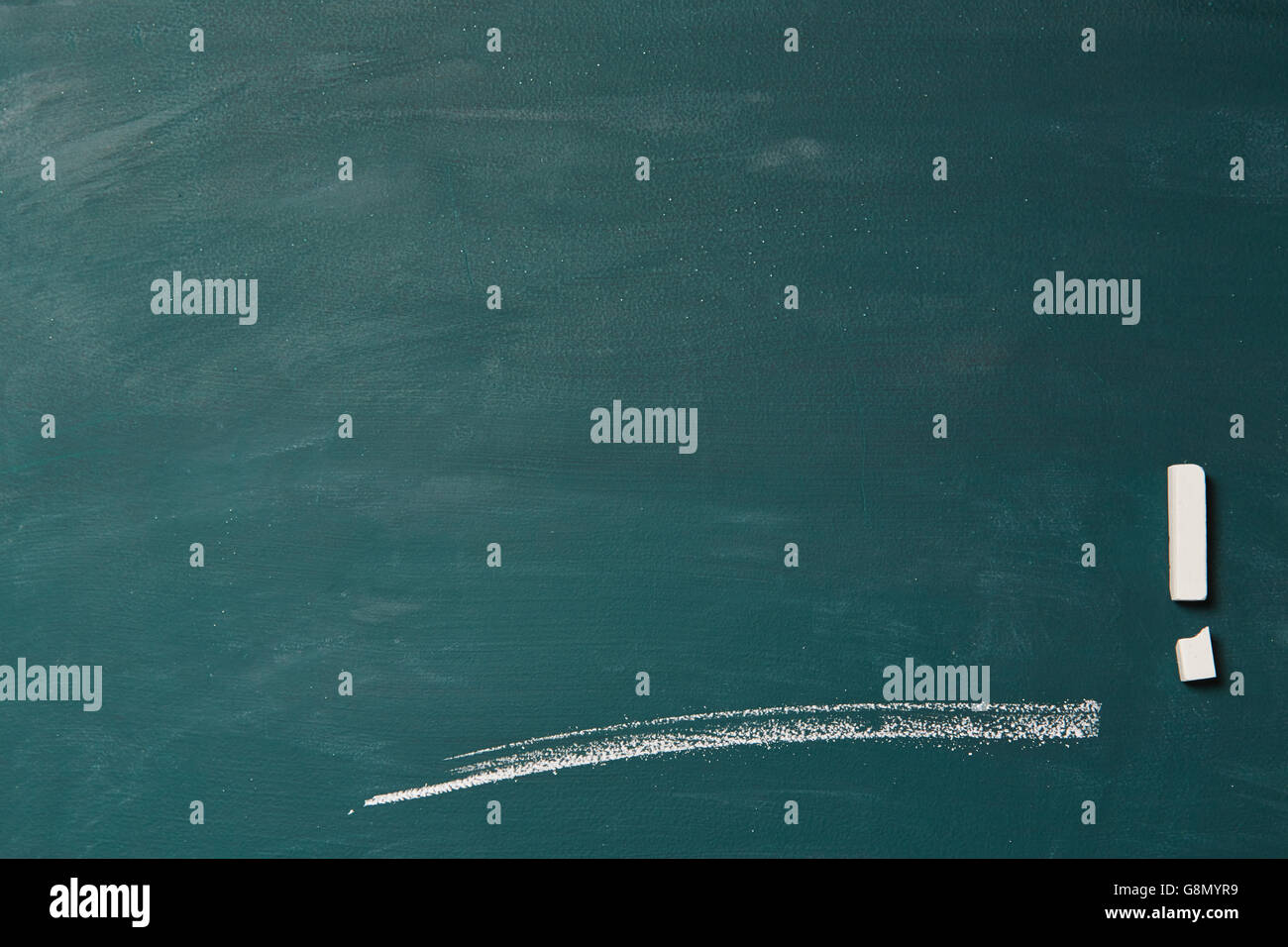 Empty green chalkboard with line and broken chalk as exclamation point Stock Photo