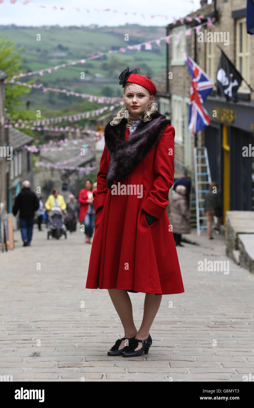 Kirsty Garwood, wearing 1940s attire, poses on the bunting draped street during the annual 1940's weekend in Haworth, West Yorks Stock Photo