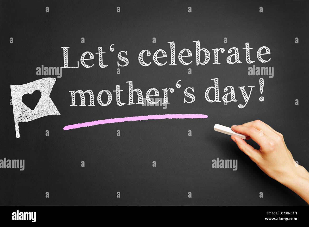 Hand with chalk writing 'Let's celebrate mother's day!' on a blackboard Stock Photo
